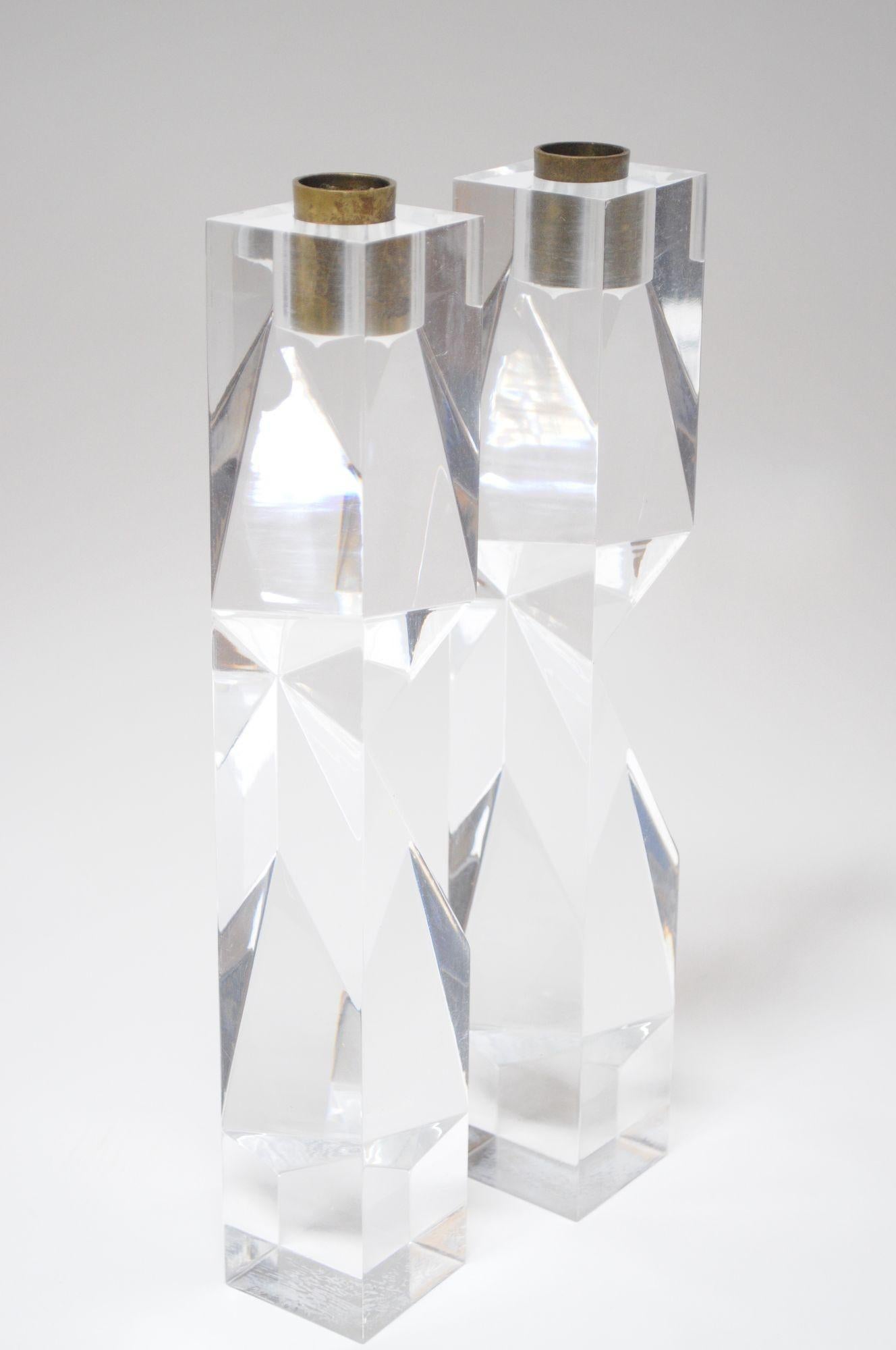 Totem scultoreo in lucite e ottone le cui sfaccettature si riflettono in modo diverso da ogni angolazione, dato il suo design asimmetrico (anni '70 circa, Italia).
Versioni di candelieri simili a sculture in lucite disegnate da Alessio Tasca. Senza