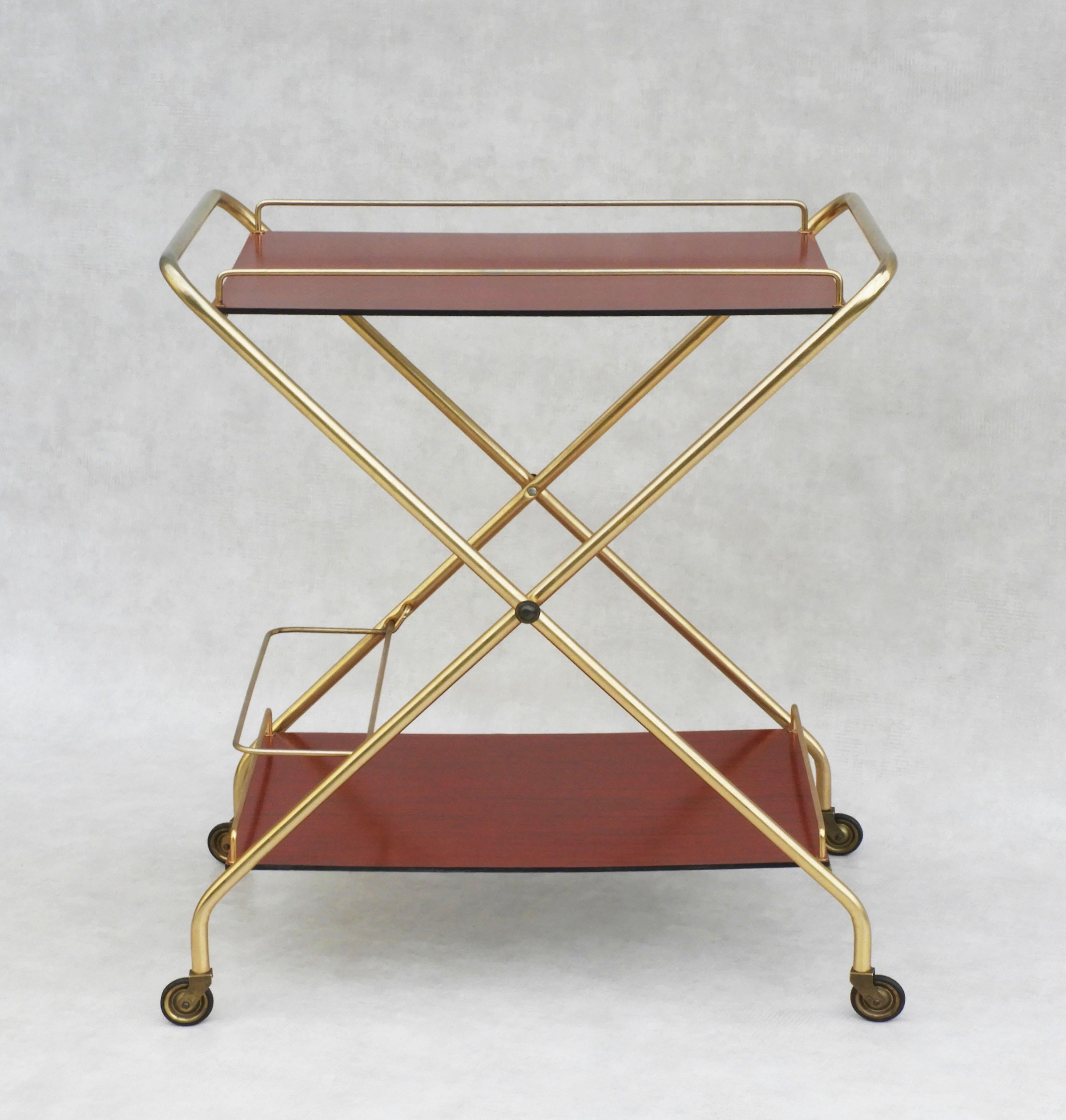 Vintage Italian bar cart c1960

Mid-Century Modern hostess trolley circa 1960s Italy.

A stylish and practical, two tiered, drinks trolley, bar cart or serving table. Gilded metal frame, printed melamine surfaces and multi-directional