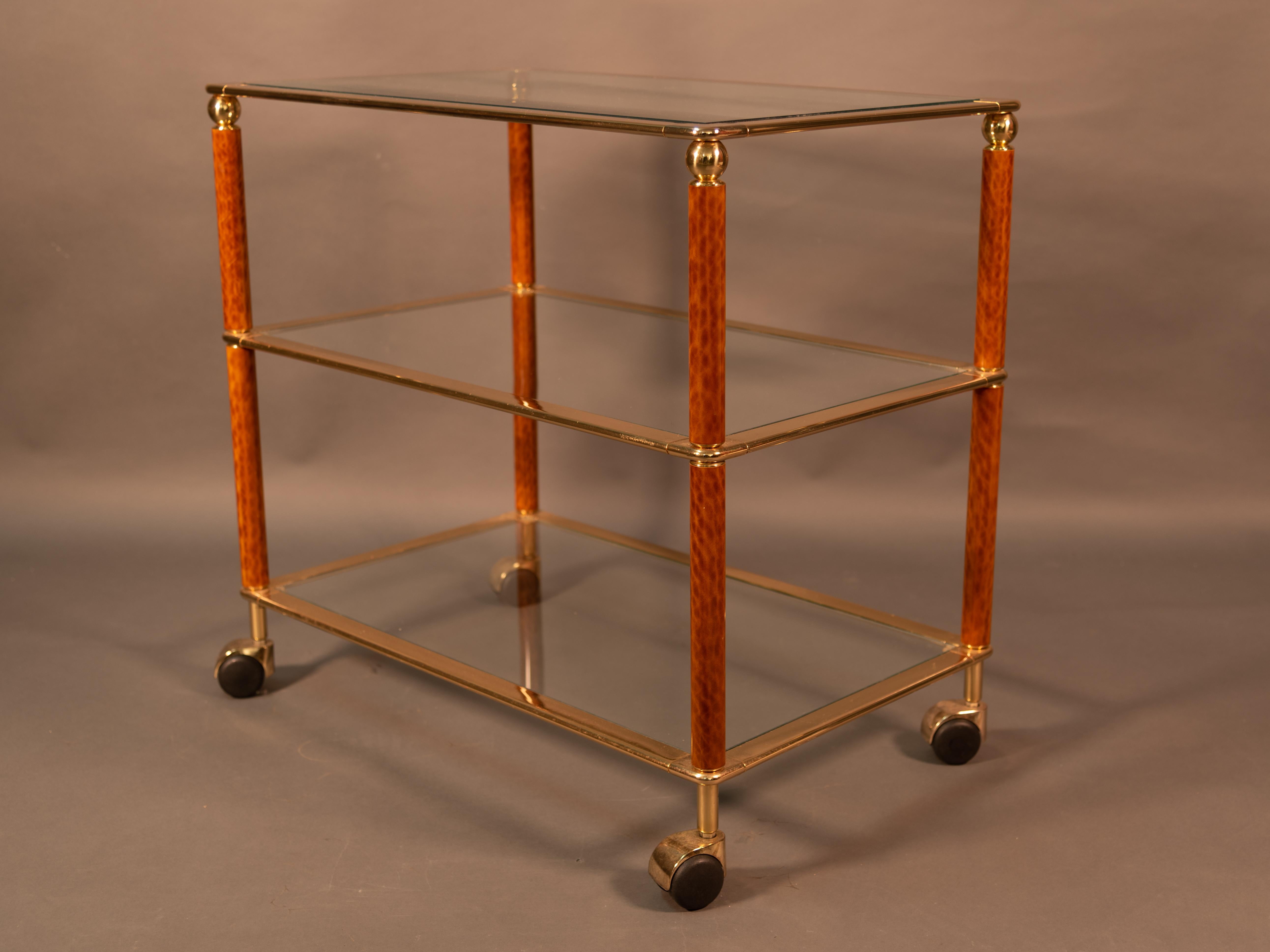 For your consideration is an very nice handsome two-tiered midcentury drinks cart or bar cart trolley.
In the style of Willy Rizzo featuring a rectangular guilted brass frame with burled wood structure, set upon four rolling casters.
 In excellent