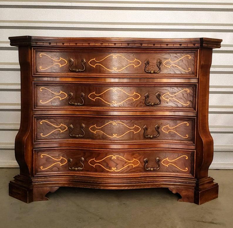 An exceptional quality vintage Italian chest of drawers. Finely hand-crafted in Northern Italy in the mid 20th century, finished in 18th century European Baroque taste, the rich, handsome antique reproduction features a thick serpentine shaped