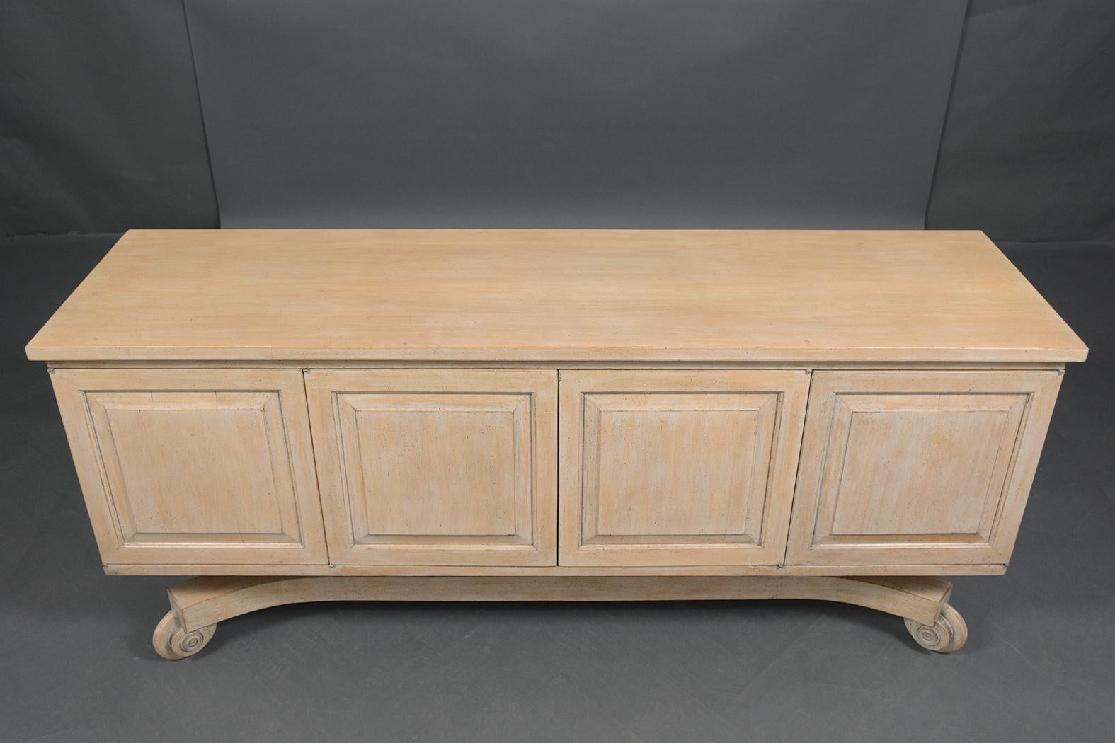 This vintage Italian buffet handcrafted out of maple wood has been professionally restored by our professional team of expert craftsmen and features a new washed finish. The piece has a solid wood top, four-paneled doors, and inside it has four