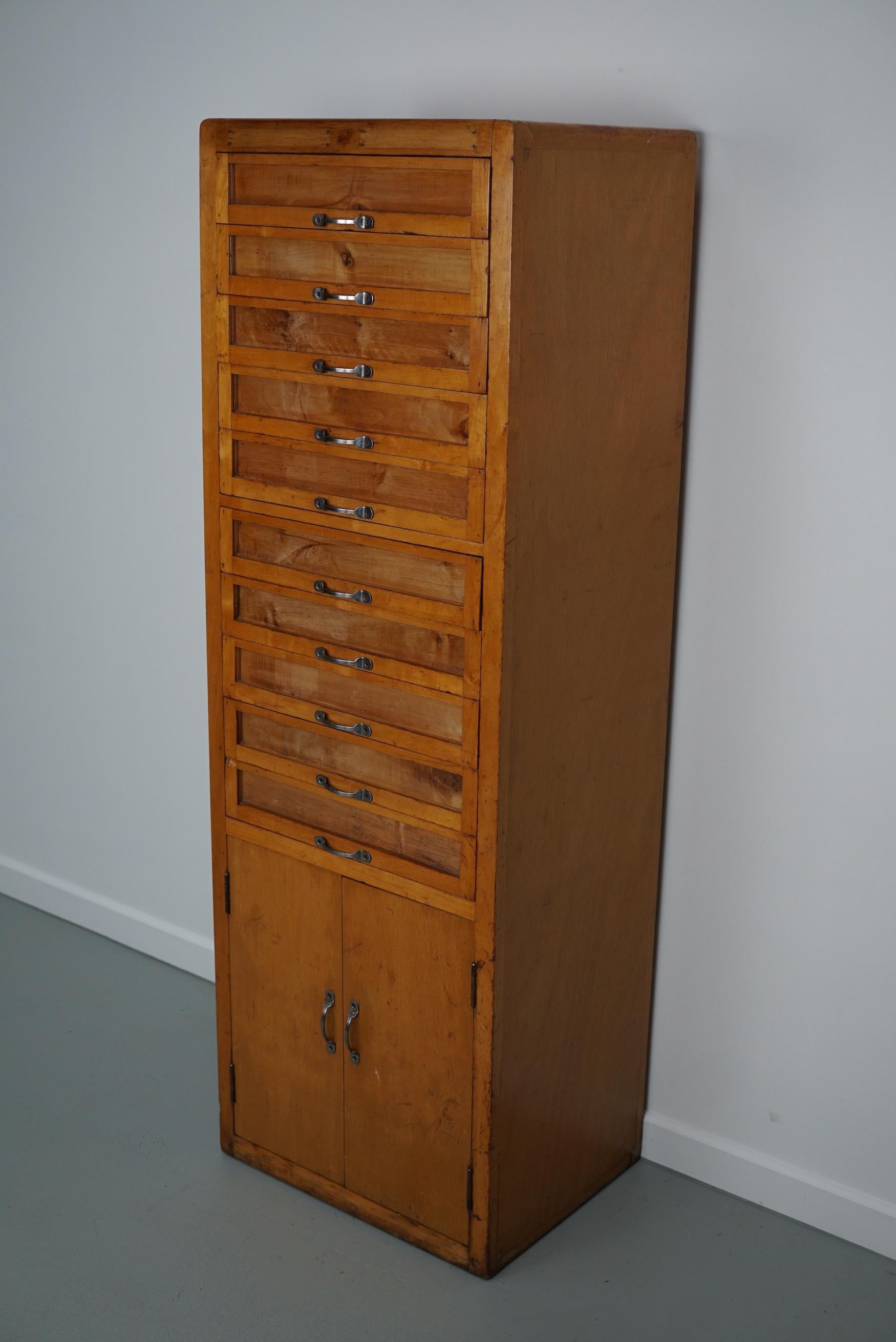 Ce meuble de mercerie a été produit dans les années 1950 en Italie. Cette pièce comporte 10 tiroirs en hêtre clair avec des façades en verre et des poignées en métal. Il était à l'origine utilisé dans un magasin de fournitures de couture et de