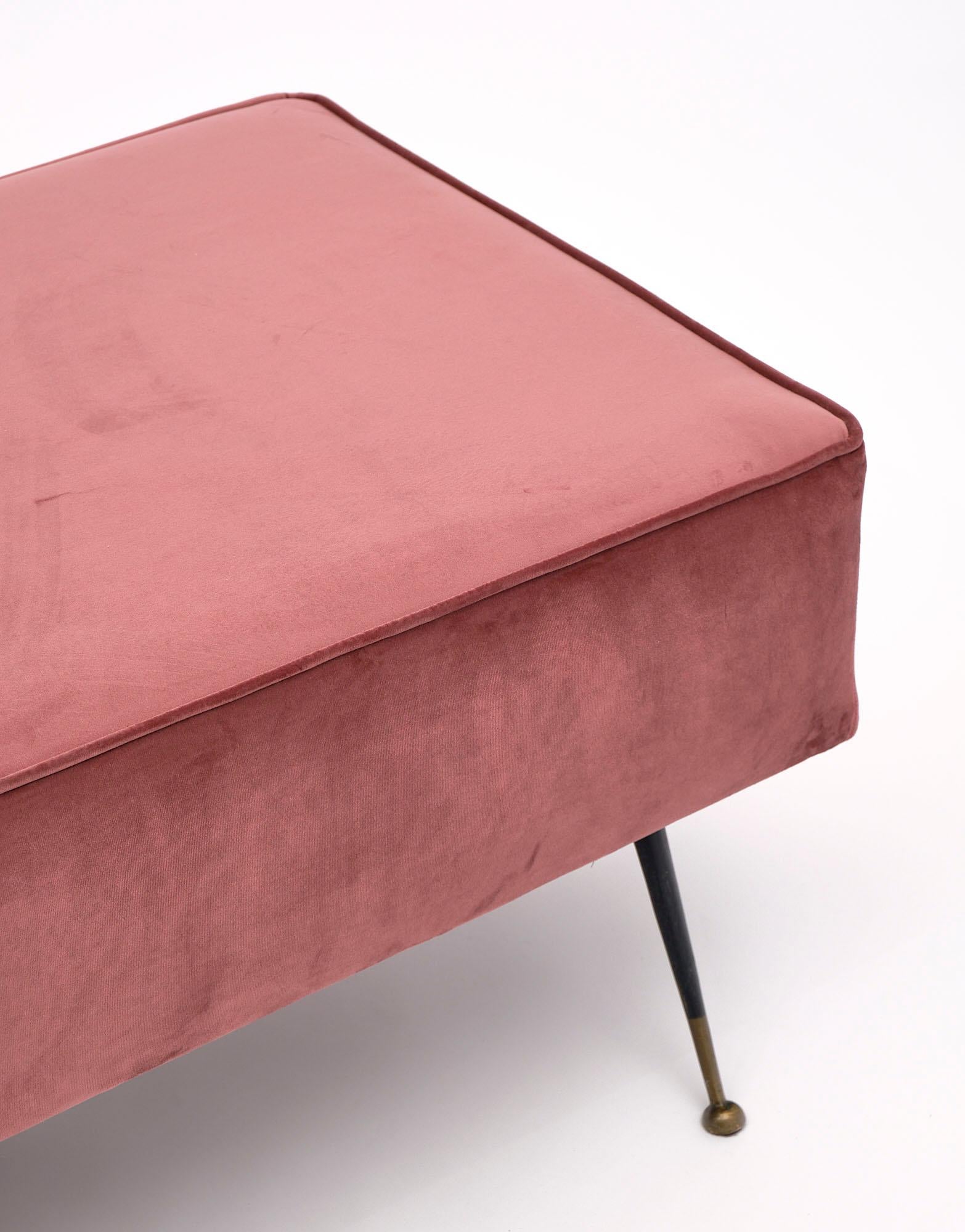 Bench, Italian, with newly upholstered seat in a pink velvet. This piece features six black lacquered legs with brass feet.