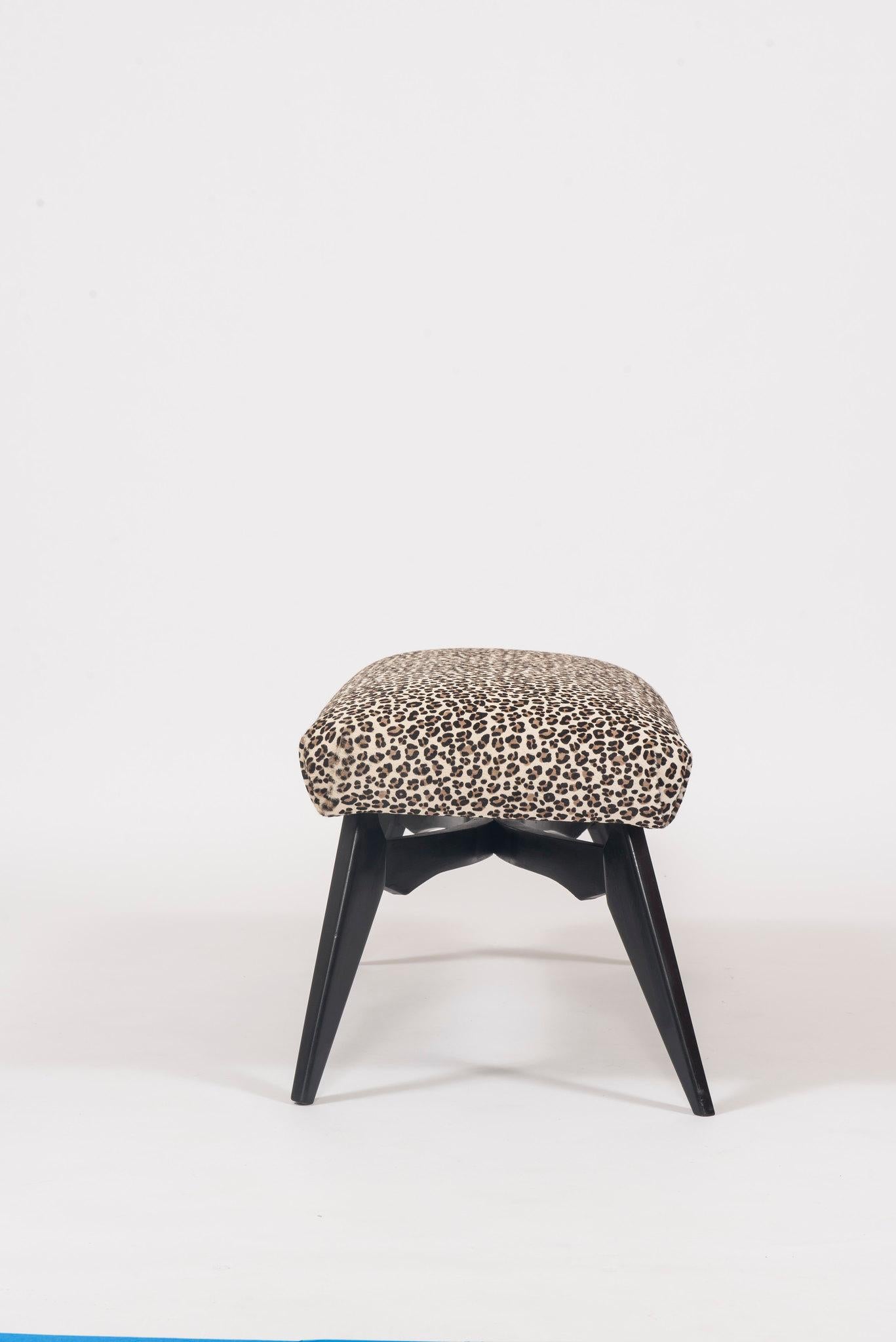 An ebonized Italian bench newly upholstered in a leopard printed hair hide.