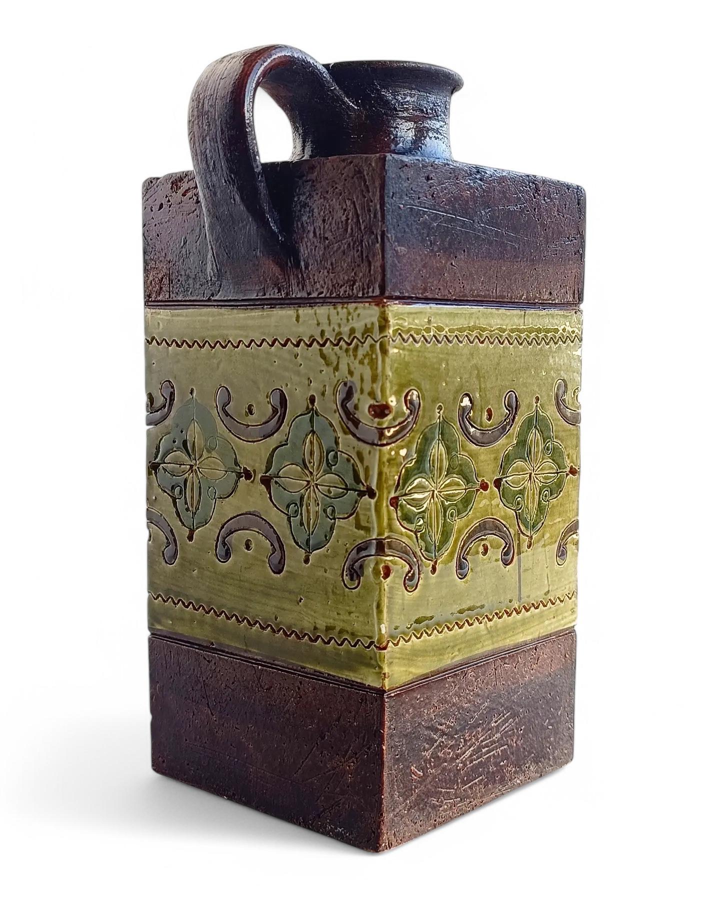 This gorgeous Italian vintage ceramic pitcher by Aldo Londi for Bitossi features  a glazing central band of the Arabesque decor in two different shades of green and the house signature dark brown rough surface, so characteristic of the Bitossi