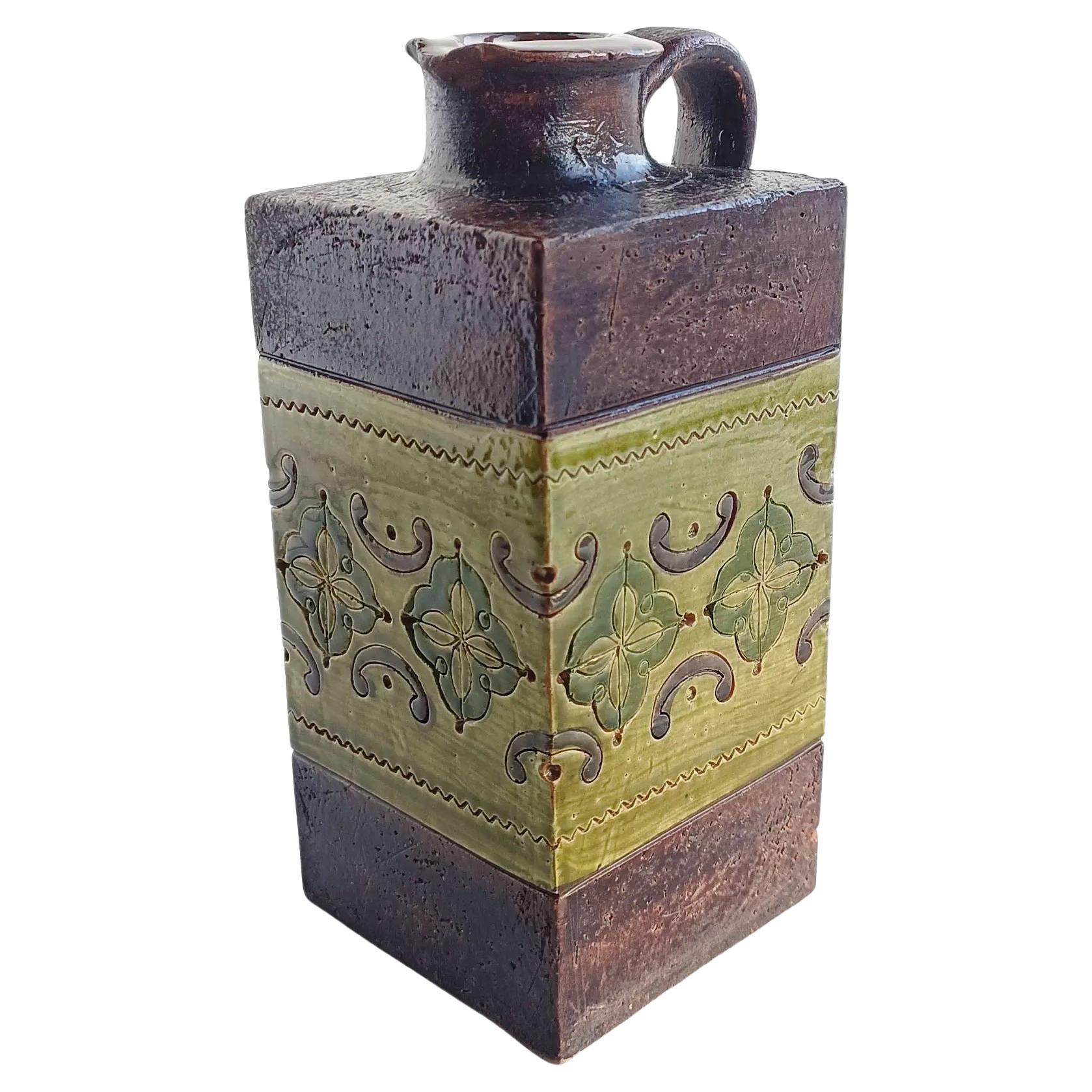 This gorgeous Italian vintage ceramic pitcher by Aldo Londi for Bitossi features  a glazing central band of the Arabesque decor in two different shades of green and the house signature dark brown rough surface, so characteristic of the Bitossi