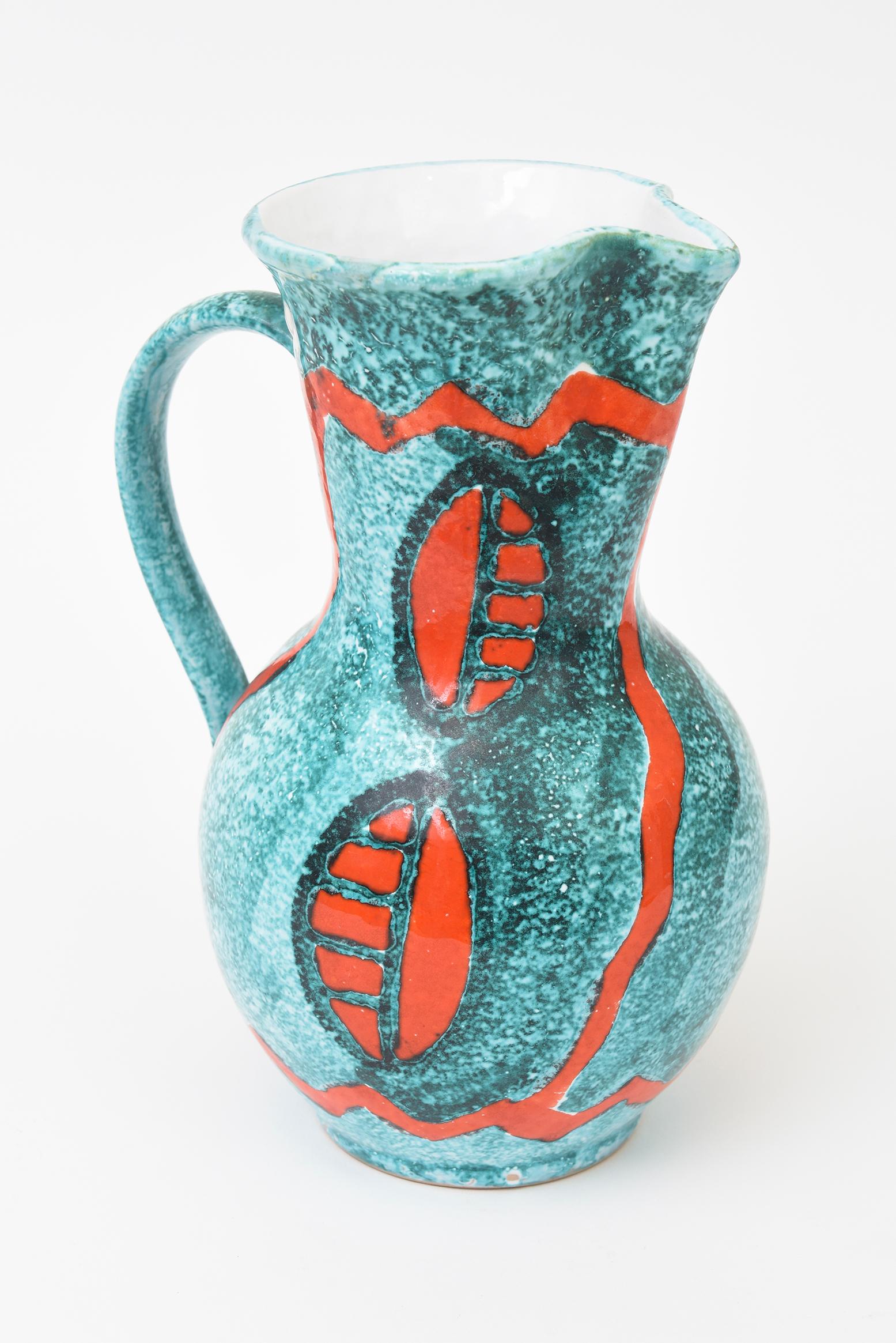 Ce magnifique pichet en céramique émaillée italienne des années 60 est orné d'un superbe motif abstrait. Attribué à Bitossi. Poinçonné sur le fond Italie 8 avec une ligne en dessous. Les couleurs sont le turquoise, le vert sarcelle, la gamme et le