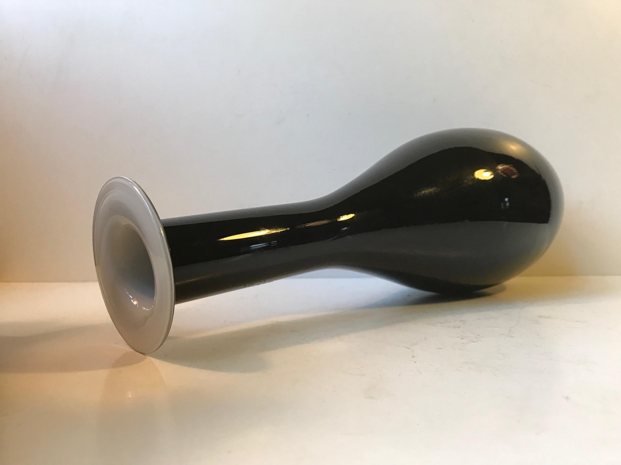 - Large organically shaped hand blown glass vase
- Made of cased black glass with an interior in opaline glass
- Made by Stelvia in Italy during the 1960s or 70s
- In a style reminiscent of Venini, Otto Brauer, and Michael E. Bang
- Free World wide