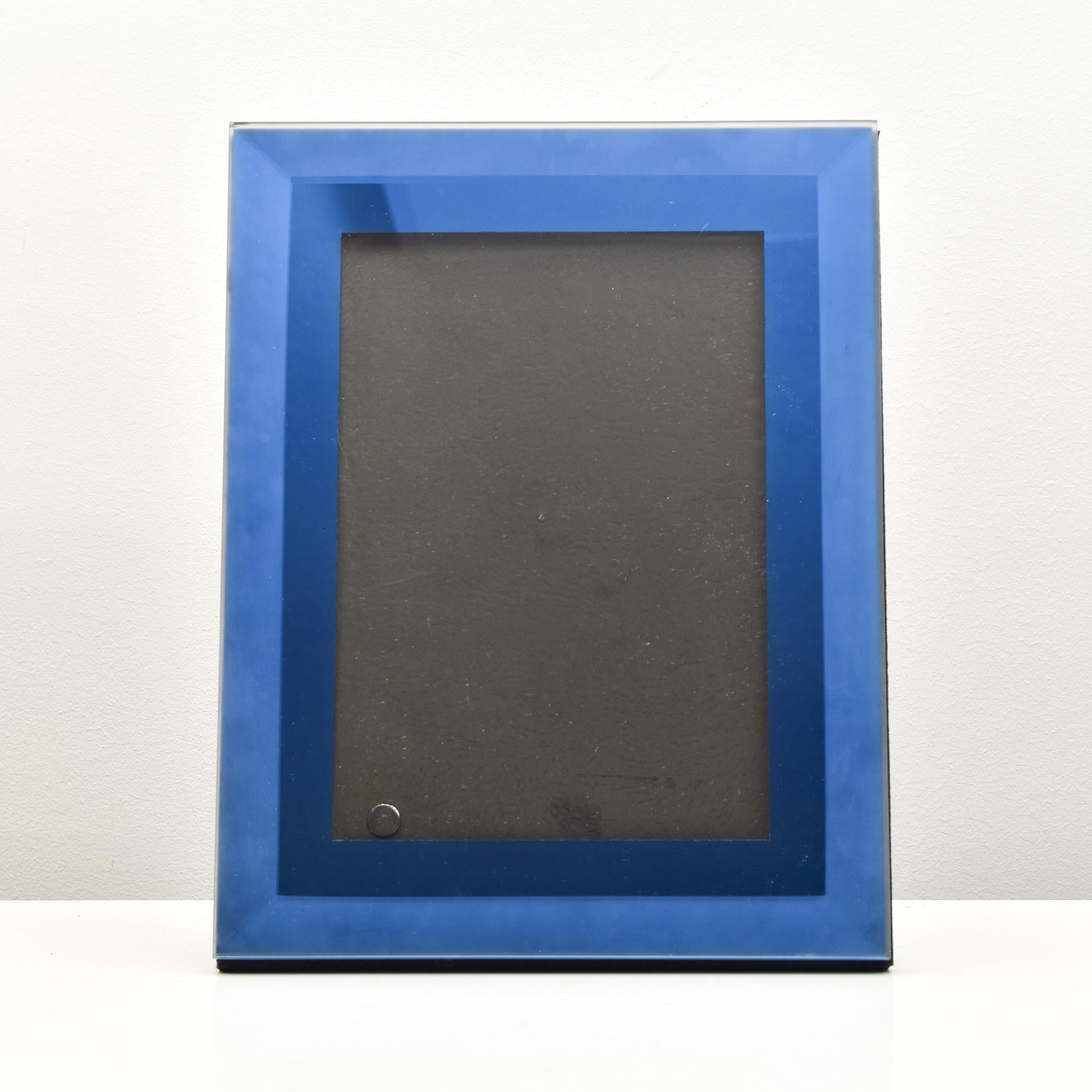 Dieser exquisite Vintage-Bilderrahmen fängt den eleganten, minimalistischen Stil ein, der für das italienische Design der Mitte des 20. Jahrhunderts charakteristisch ist. Mit einer teilweise satinierten blauen Glaseinfassung bietet dieser Rahmen