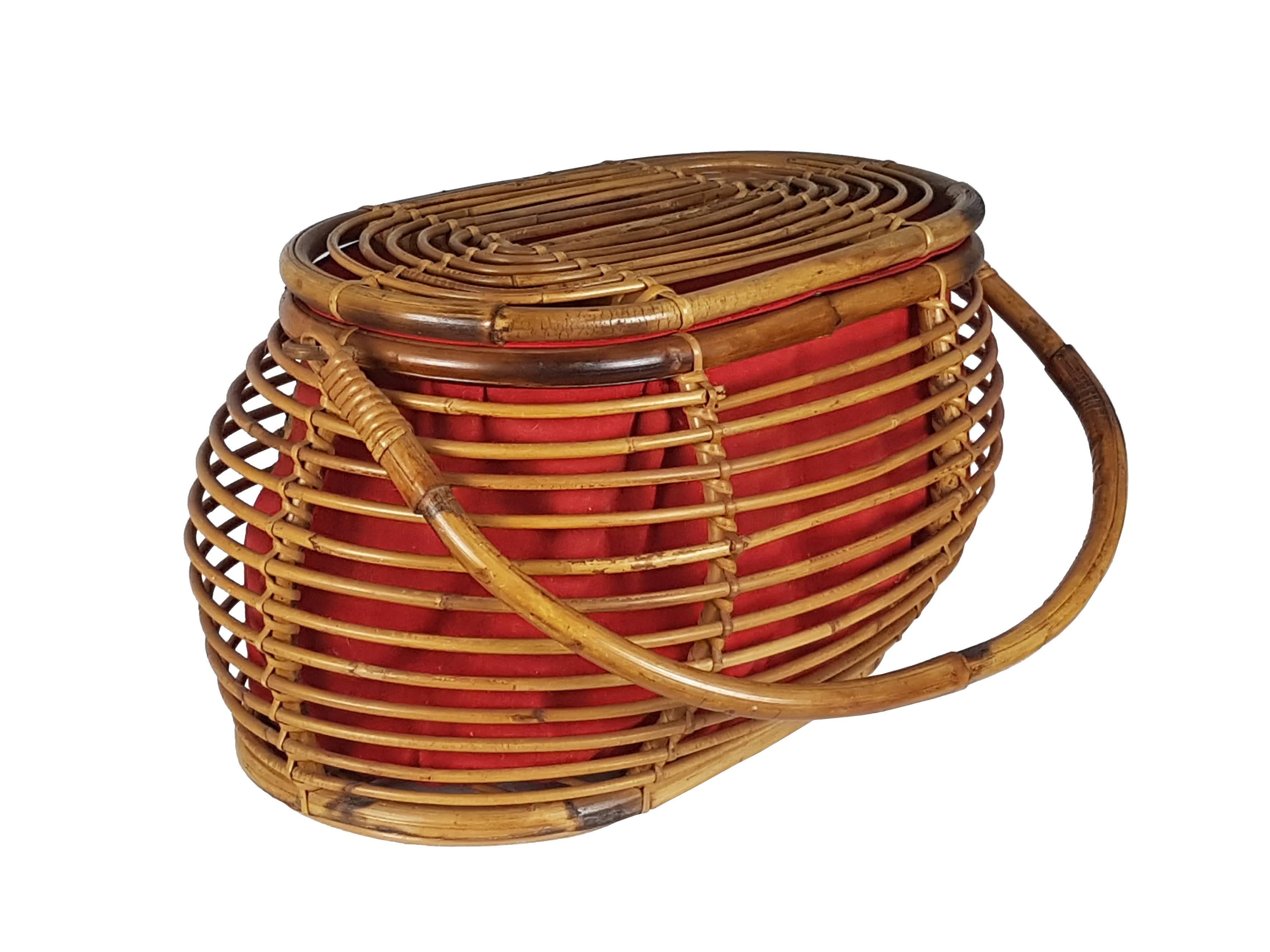 This vintage box is made from a rattan frame with a red fabric bag. It features a useful lid and practice handle. It can be used as a magazine rack or as a generic glove box. Its style and quality resembles similar Bonacina products. Good vintage