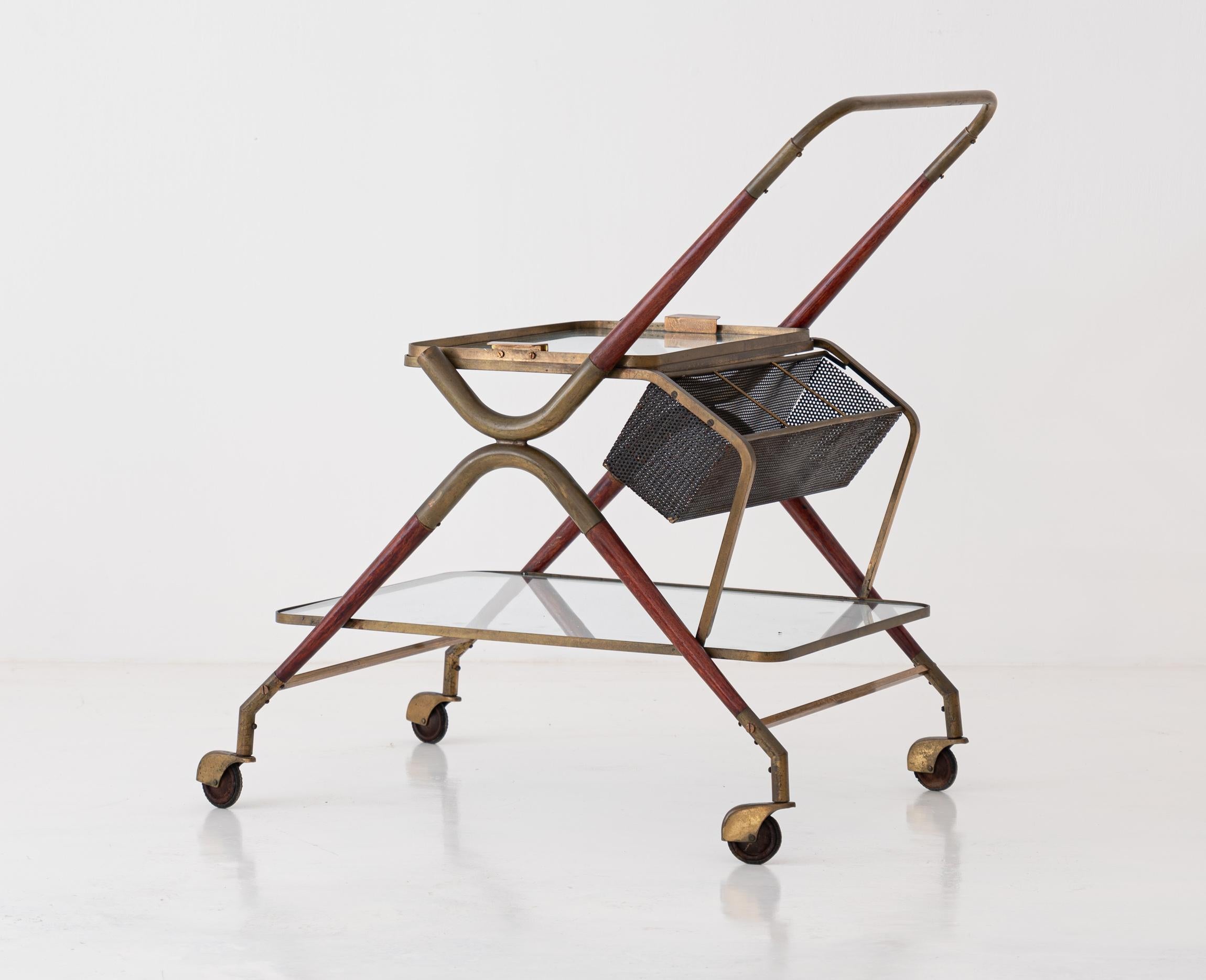Mid-Century Modern service trolley or bar cart, manufactured in Italy during the 1950s.

The whole frame is in brass with parts in lacquered wood.
The upper plane have a glass tray. 
The lower plane is in glass. 




 