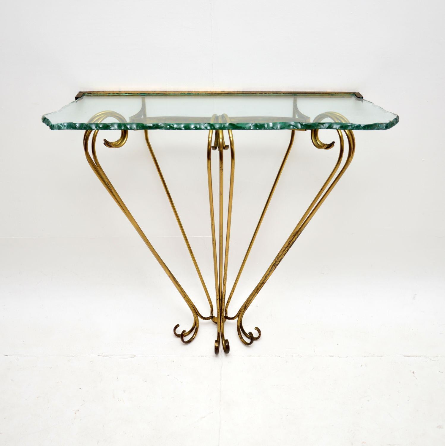 A stunning vintage Italian brass and glass console table by Pier Luigi Colli. This was recently imported from Italy, it dates from the 1970’s.

It has a gorgeous design and is of superb quality. The solid hammered brass frame has beautiful curves,