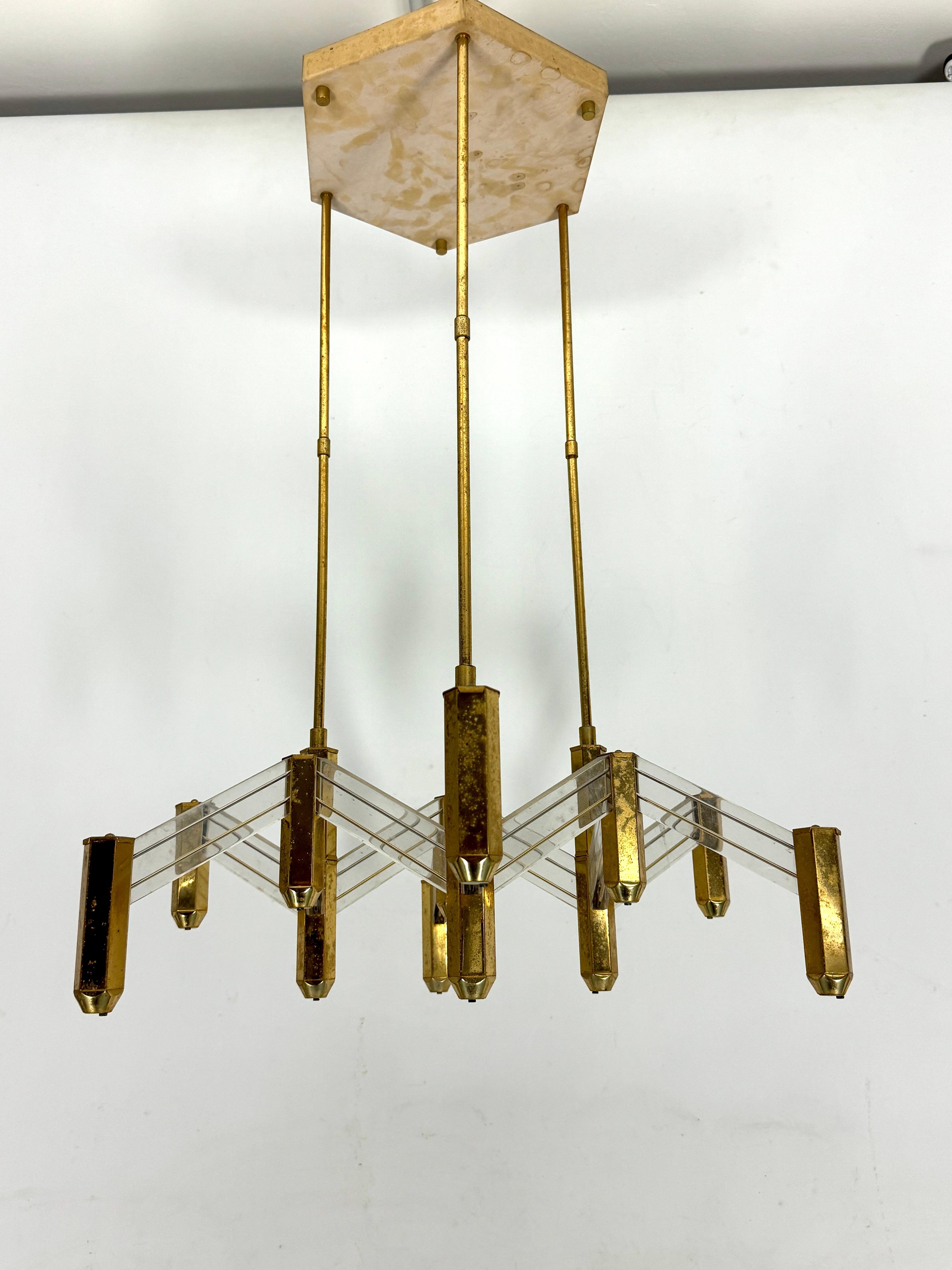 Good vintage condition for this chandelier made from brass and perspex and produced in Italy during the 70s from Zeroquattro. It mounts 12 sockets for halogen lamps model G4. Full working with EU standard, adaptable on demand for USA standard.
