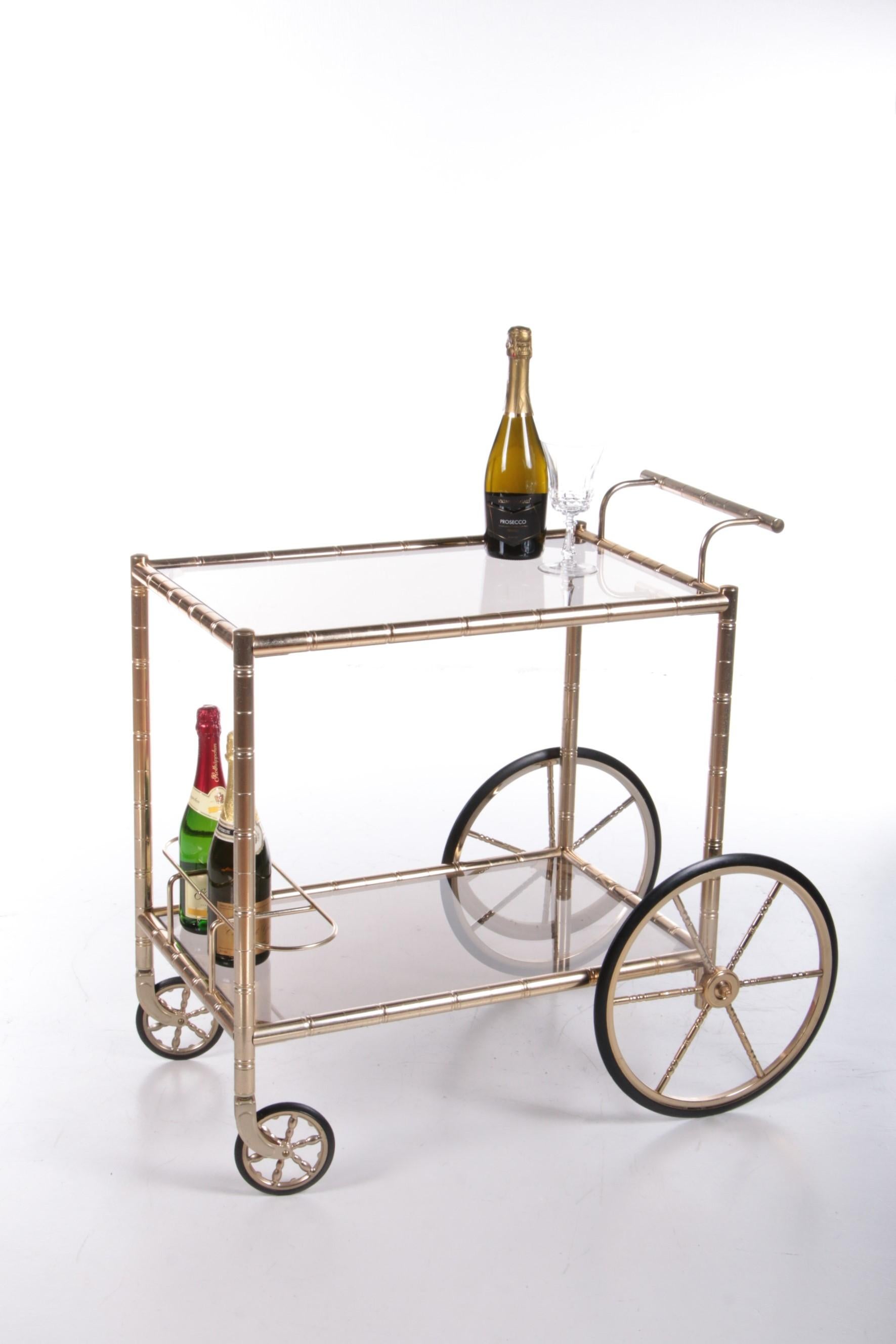 A beautiful trolley with gold accents and two beautiful glass tabletops.

Two racks have been installed on the lower level to store a bottle of wine or other drinks.

The table tops are made with beautiful and sturdy glass plates. They also call