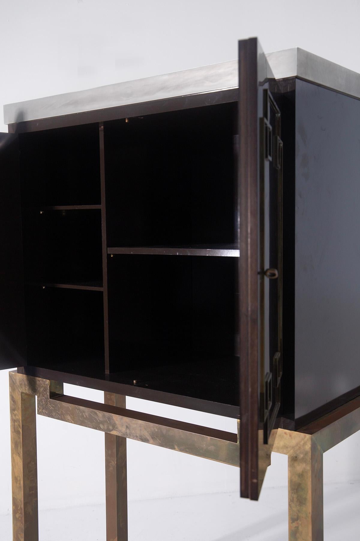 This elegant tall Italian bar cabinet, dating from the 1960s, is a fine example of the Art Deco style reinterpreted with the taste and craftsmanship of postwar Italian design. Made of lacquered wood in a sophisticated dark brown, almost black, this
