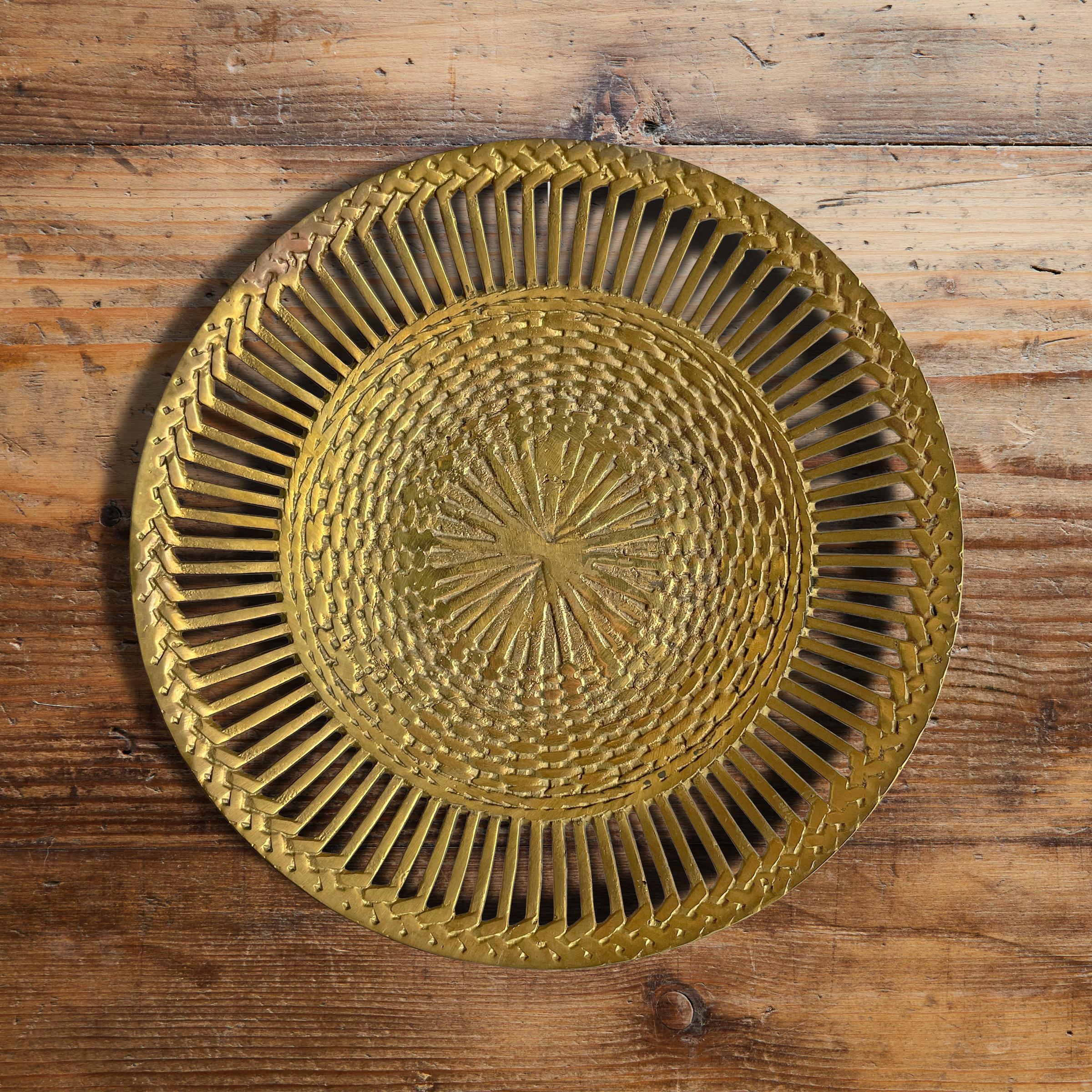 A vintage Italian cast brass bowl with a woven basket pattern and a pierced edge detail. Perfect for catching your keys wallet, and pocket change in your bedroom, or holding your mail in your entry.
