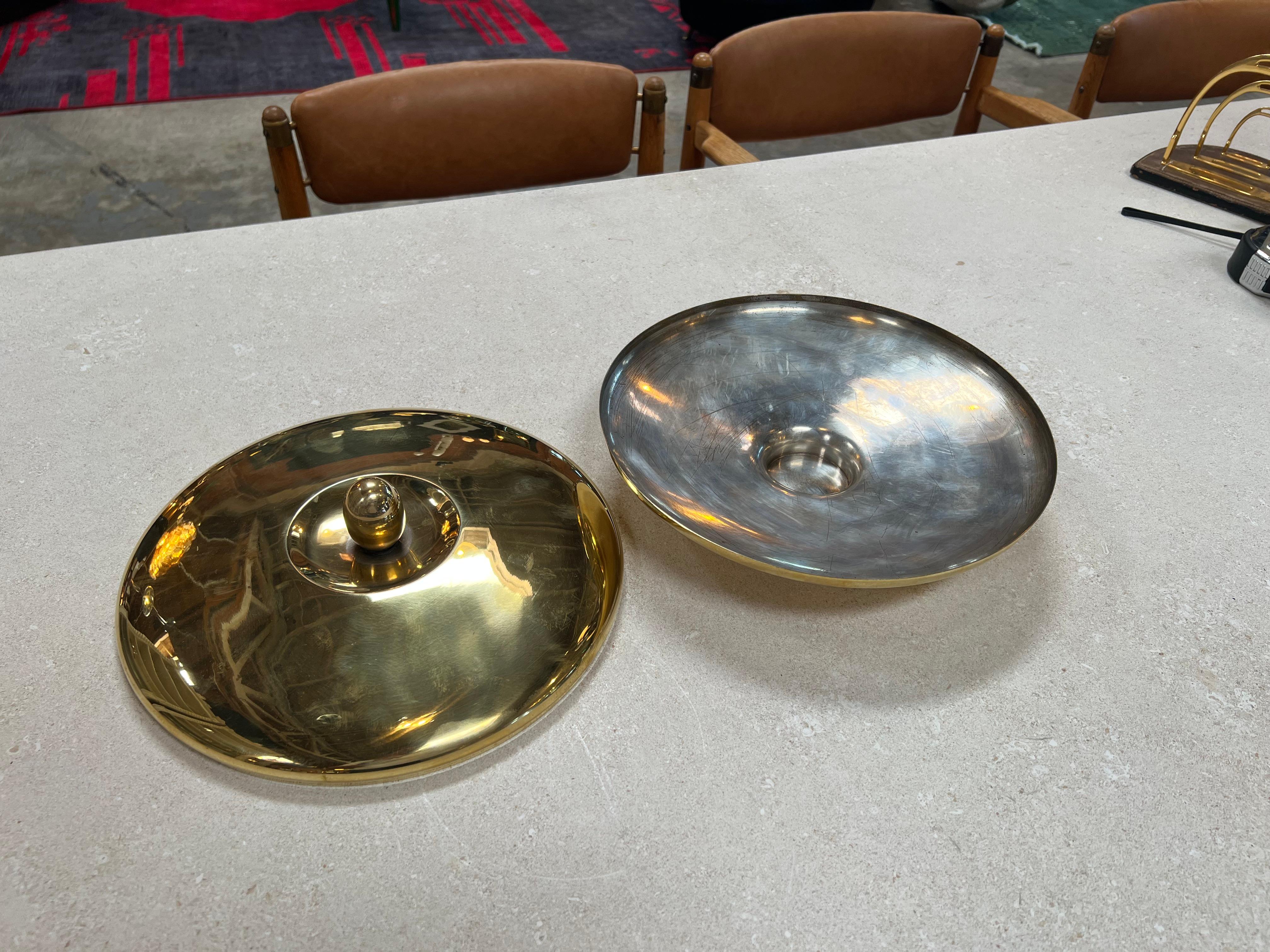 The Vintage Italian Brass Center Bowl from the 1960s is a captivating embodiment of Italian design and craftsmanship. This centerpiece exudes a timeless elegance with its rich brass material and refined construction. Its sleek lines and attention to
