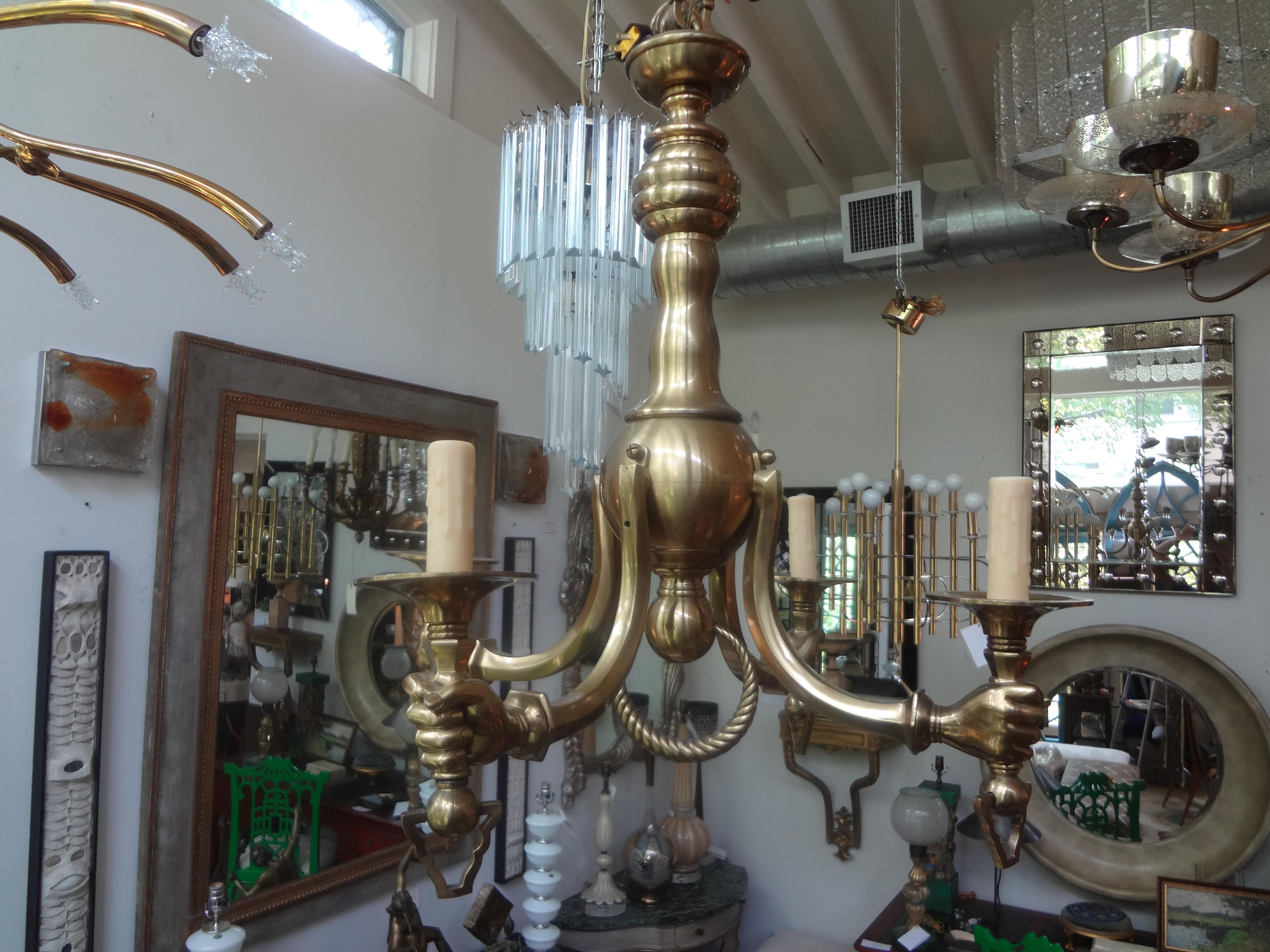 Unusual vintage Italian four arm brass chandelier with hands. This gorgeous well made heavy Italian Hollywood Regency brass chandelier has been newly wired and has a soft aged patina.