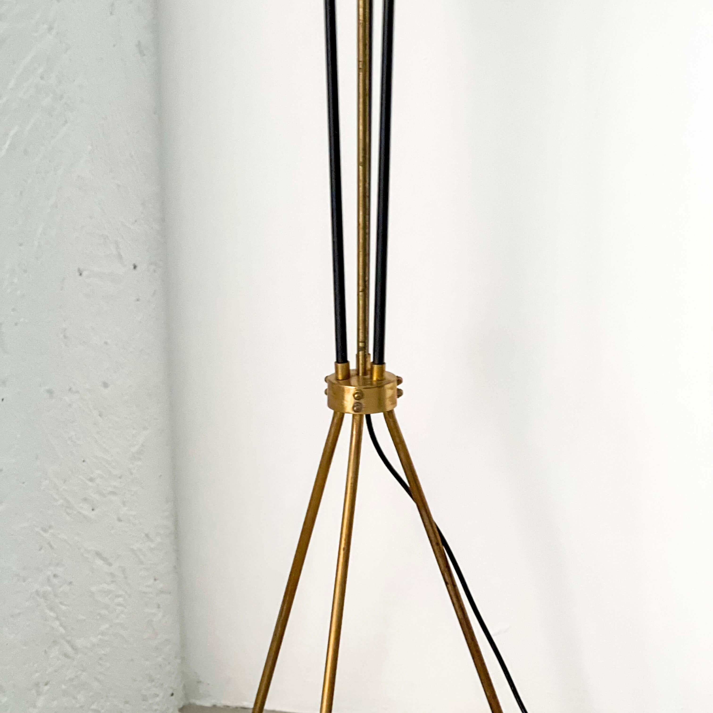 Offered for sale here is a beautiful, rare and well preserved floor lamp, produced in Italy and dating back to the 1950s. It is a floor lamp of medium height, with a thin base consisting of three elegant brass legs. On top of the legs, three brass