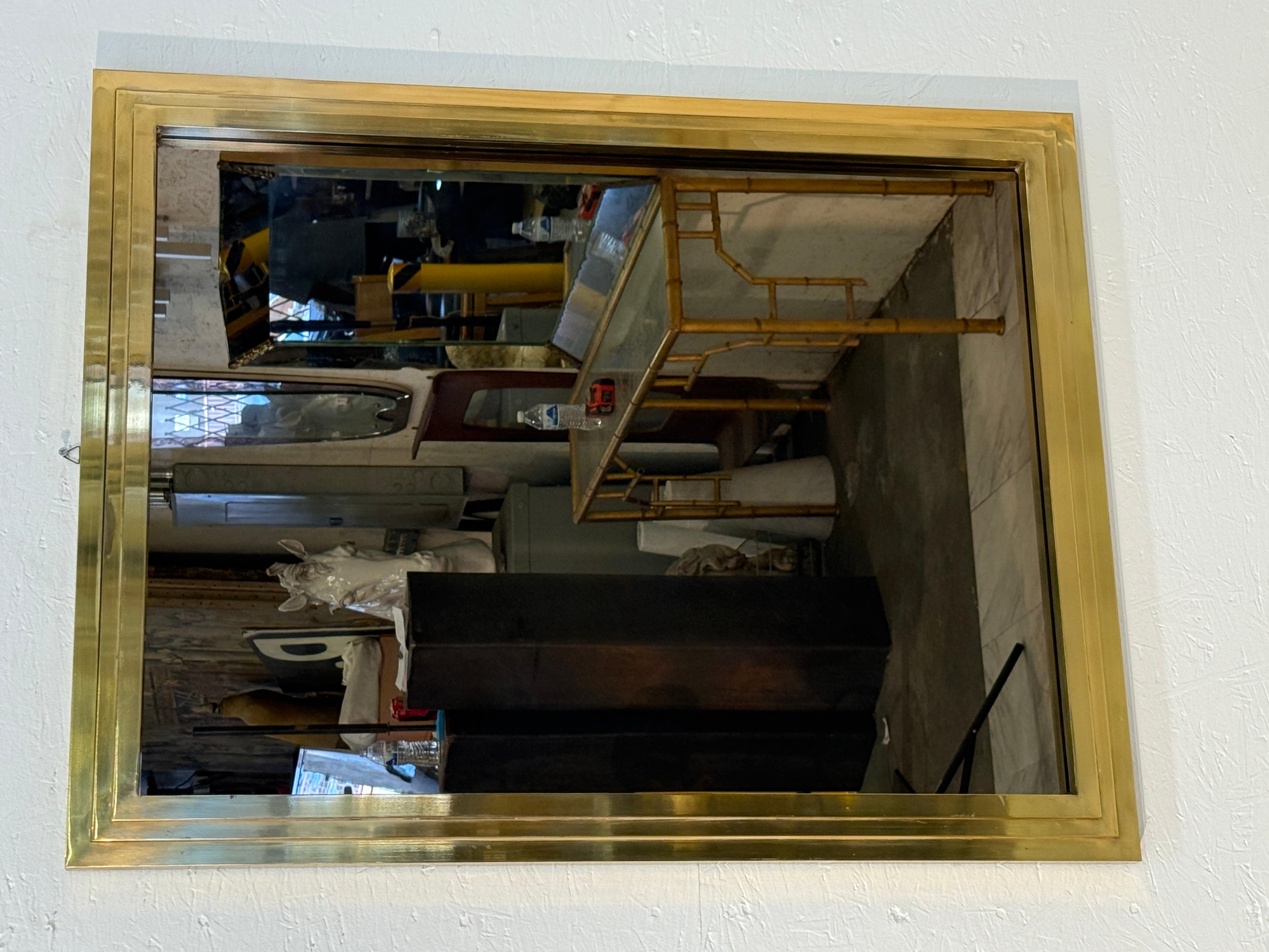 Un élégant miroir mural rectangulaire avec un cadre en laiton audacieux, mettant en valeur des lignes épurées et un savoir-faire raffiné. La conception du cadre en couches crée de la profondeur et ajoute une qualité architecturale subtile, tandis