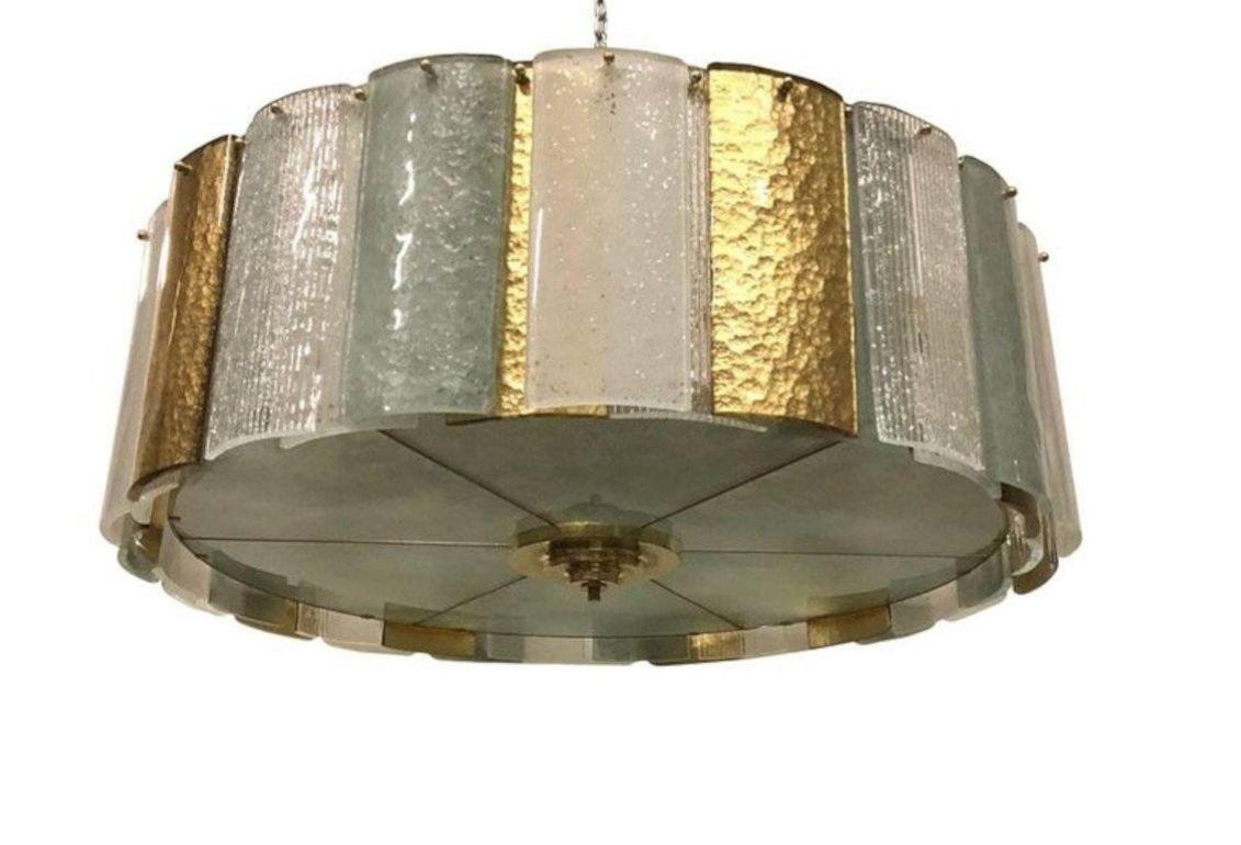 Gorgeous vintage chandelier made of clear ribbed, frosted and gold textured Murano glass tiles. The light fixture is mounted on a brass structure. Made in Italy, c. 1980's.
*Rewired to fit US lighting standards.
Dimensions:
17