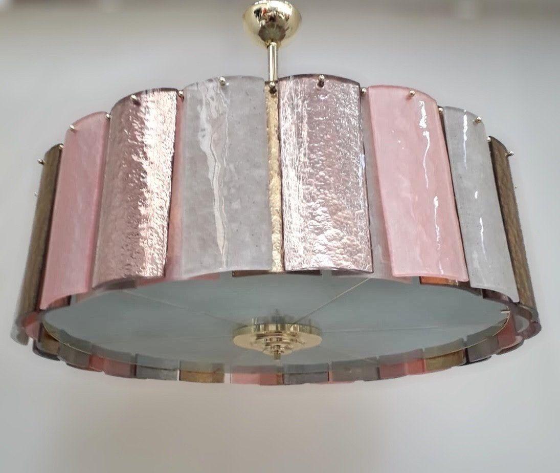Gorgeous vintage chandelier made of clear ribbed, frosted and pink and purple textured Murano glass tiles. The light fixture is mounted on a brass structure. Made in Italy, c. 1980's.
*Rewired to fit US lighting standards.
Dimensions:
17