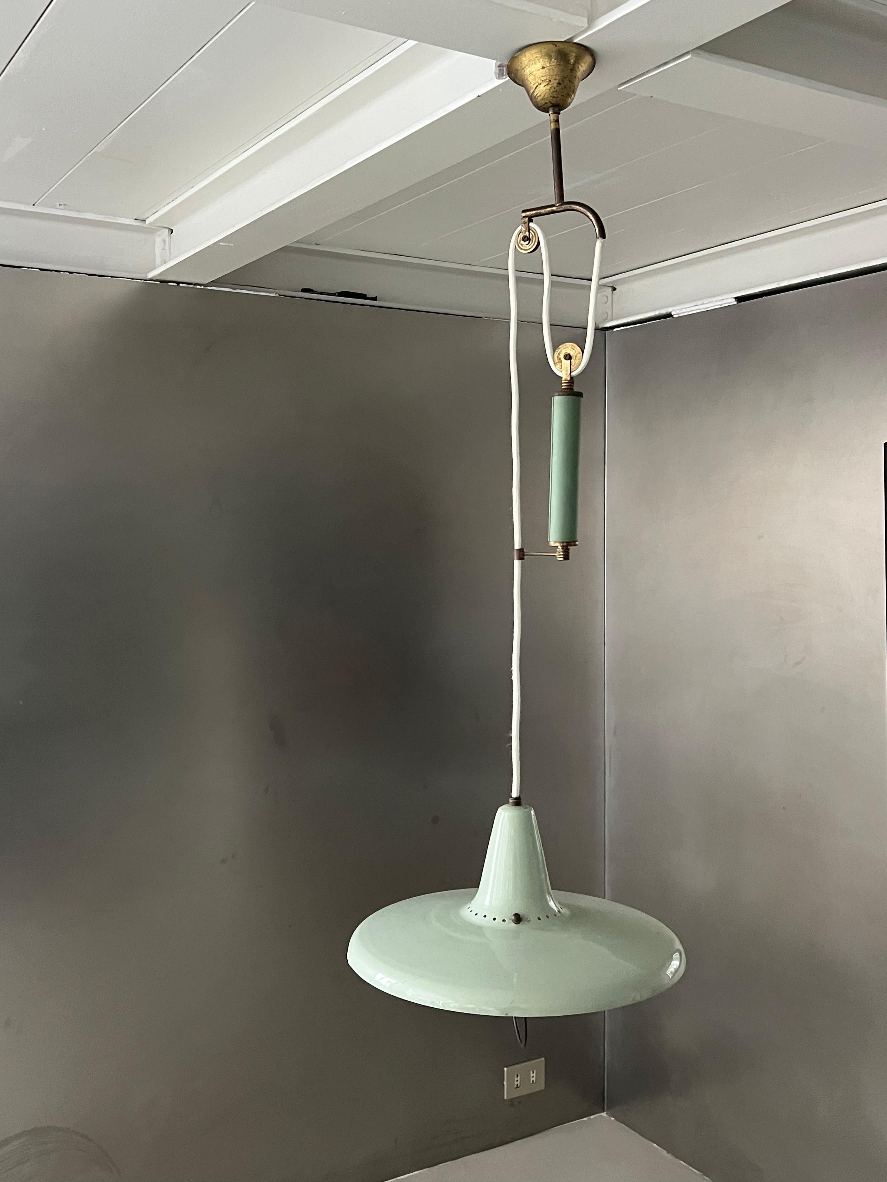 Lámpara colgante rara y bien conservada, fabricada en Italia y que data de la década de 1950, diseñada por Gaetano Sciolari para Stilnovo,
fabricado en componentes de latón como las ruedas que permiten que el cable se extienda verticalmente subiendo