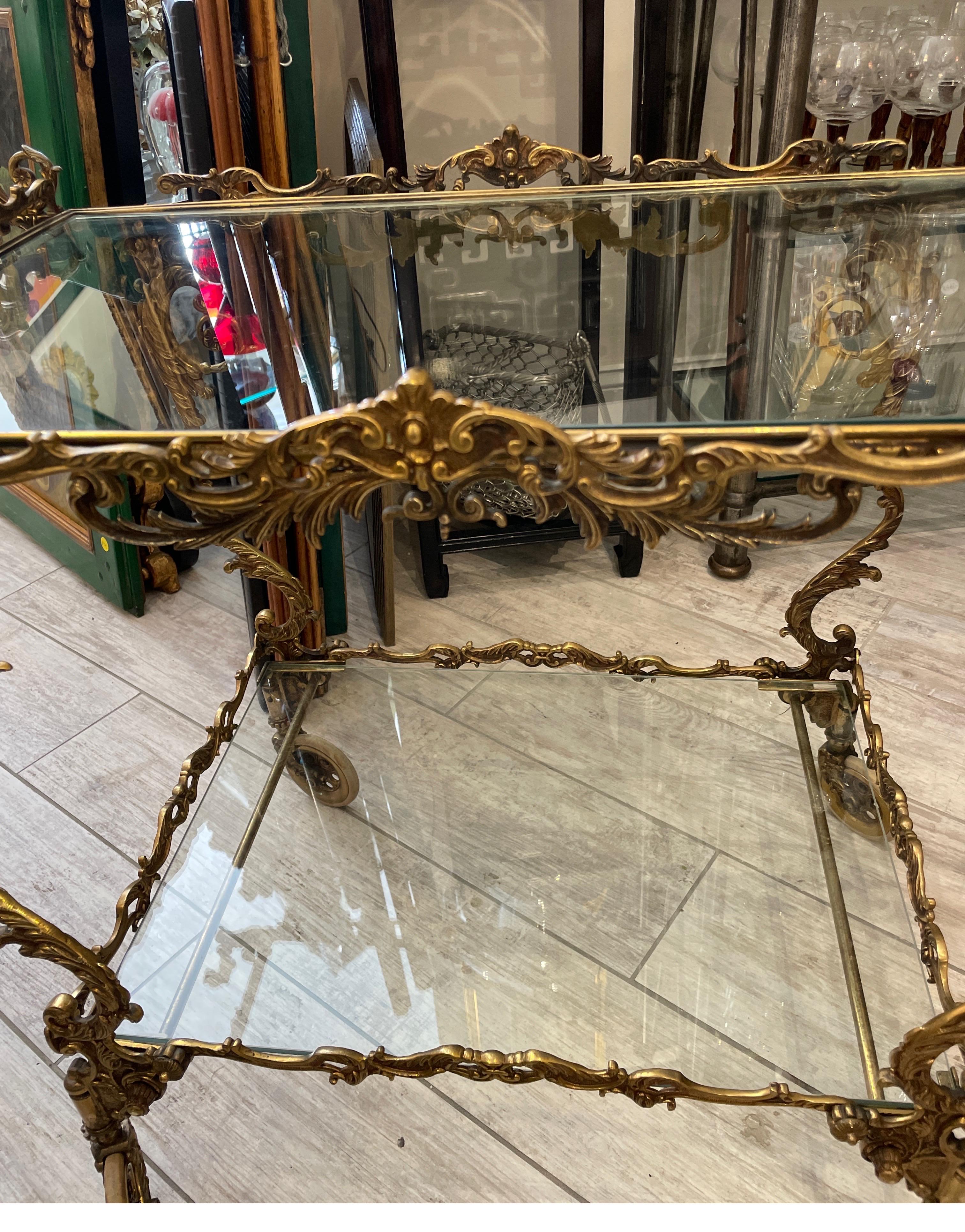 Outstanding example of Italian Rococo two tiered bar cart. This cart is made of solid brass with much attention paid to detail. All sides are beautifully designed with scrolls and sea urchins. This cart is truly a gem.