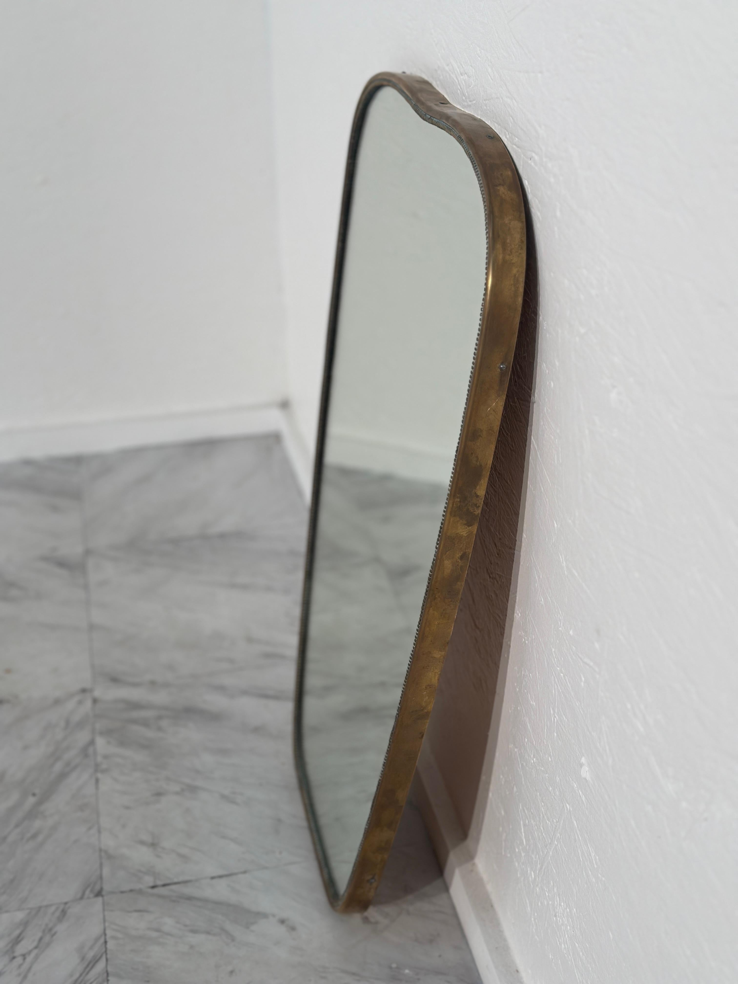 The Vintage Italian Rectangular Wall Mirror from the 1960s boasts a brass frame with original patina, showcasing its elegant aged character in a sleek, timeless design.


