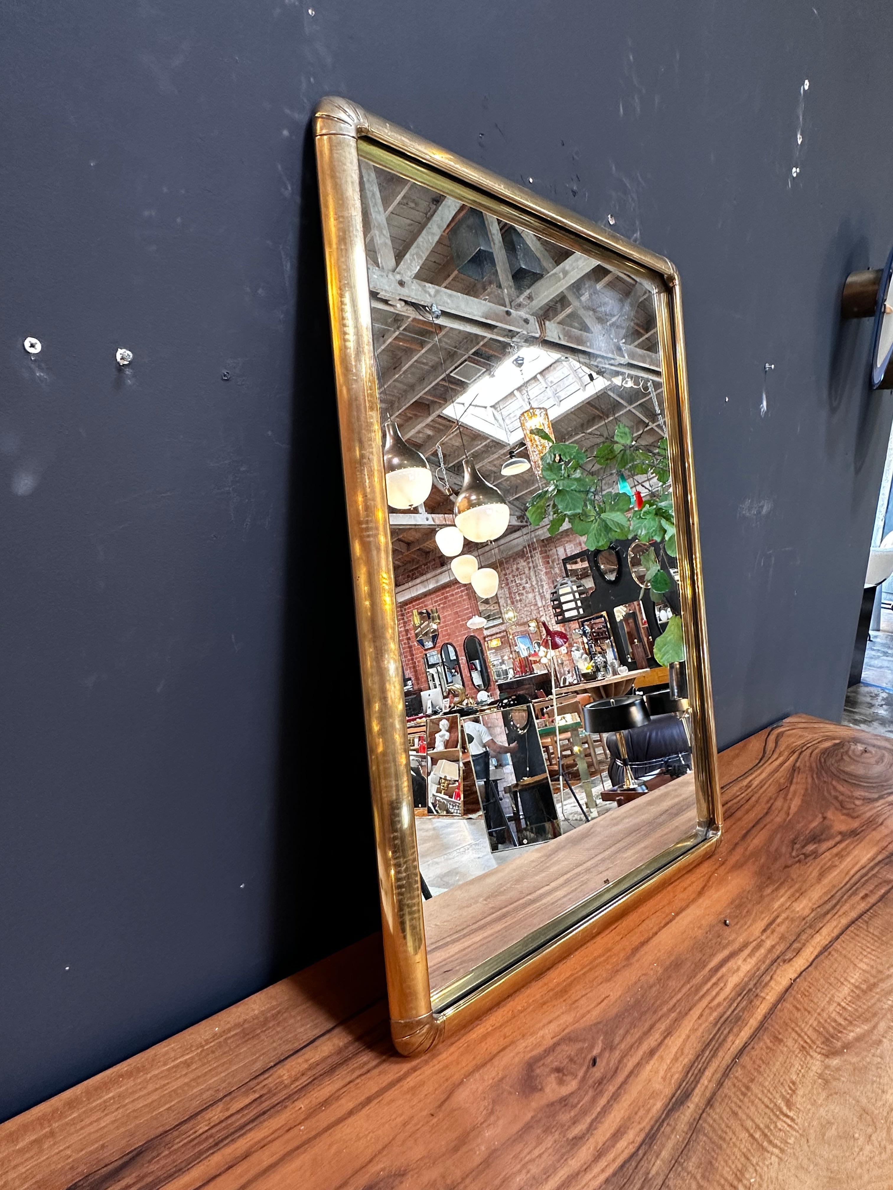 The Vintage Italian 1980s Brass Wall Mirror is a classic and timeless piece with a beautiful brass finish.

