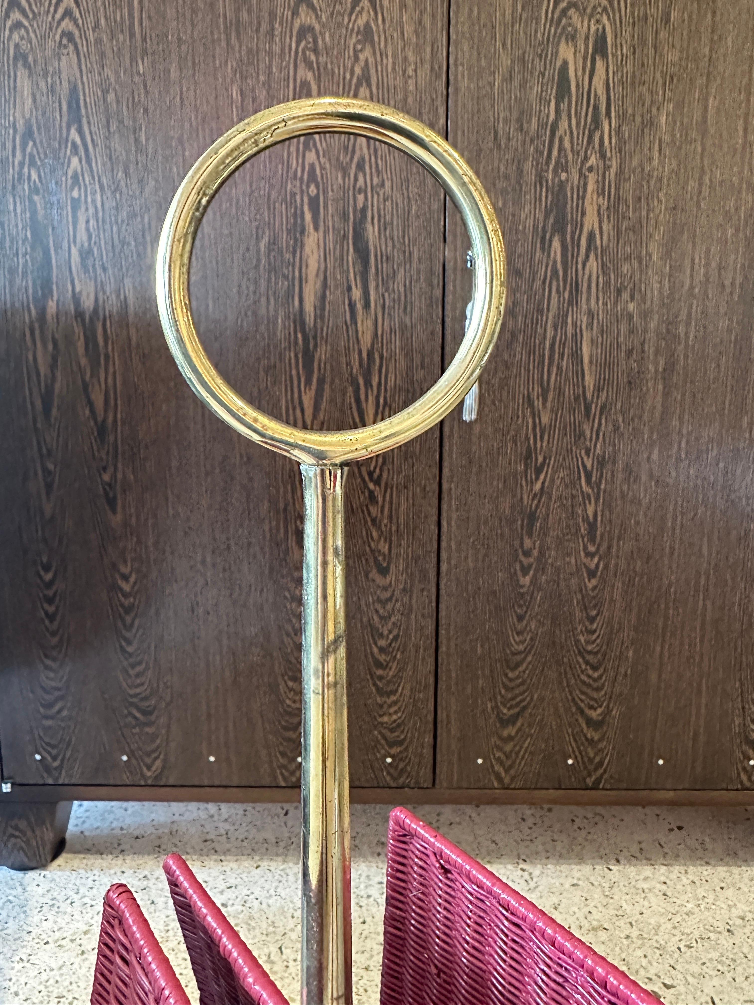 The amazingly classic Italian design of the brass ringlet and sculptural legs makes this magazine stand such an amazing find.  The pink painted wicker floats on this piece of art, holding two areas for magazines, etc.  Chic design is reminiscent of