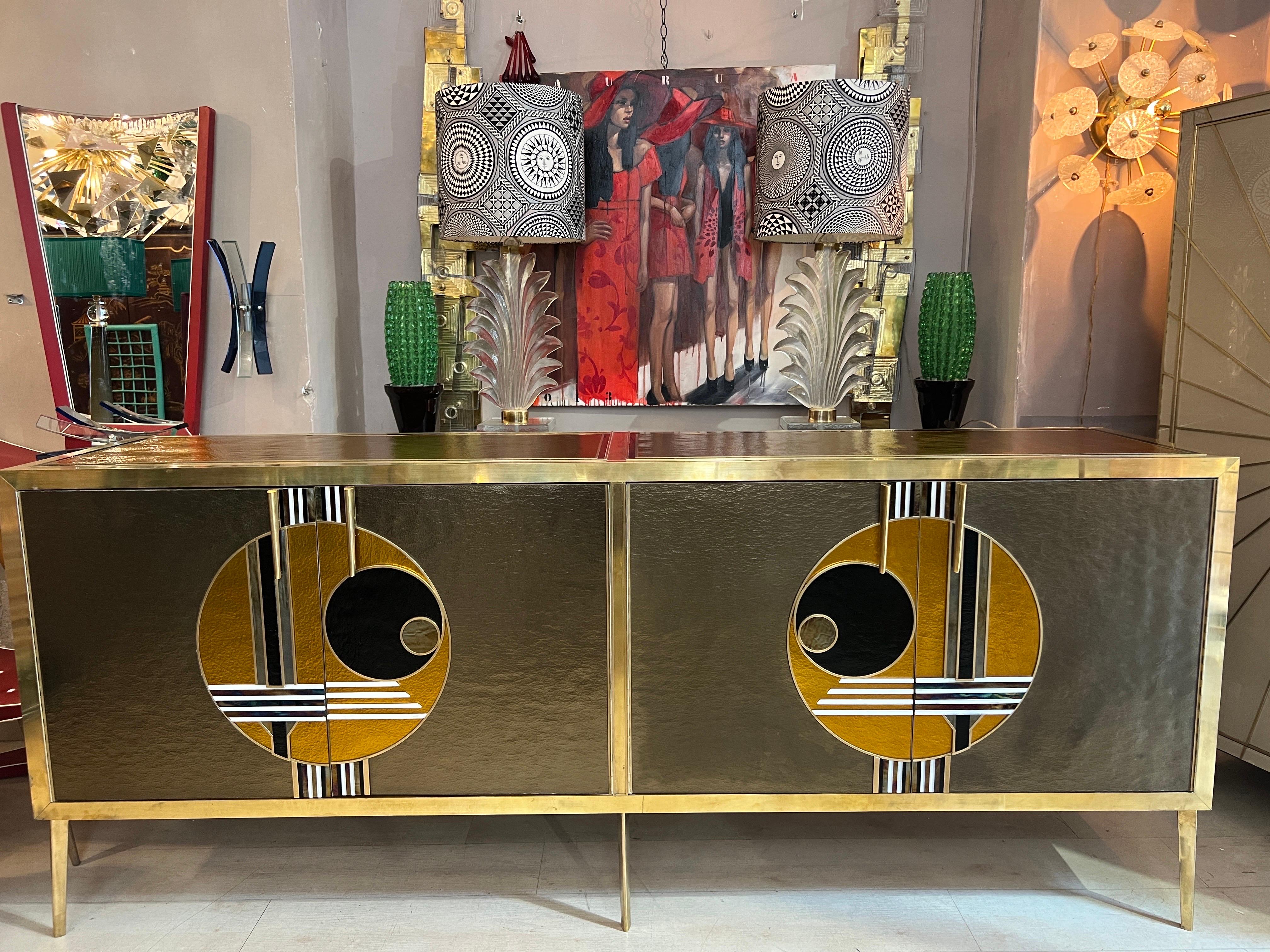 Vintage Italian Bronze and Gold Opaline glass credenza with 4 doors with shelf inside. Front Door with two geometric modern designs in brass edges with multicolored opaline glass (bronze, gold, black, white and iridescent).
The inside has been newly