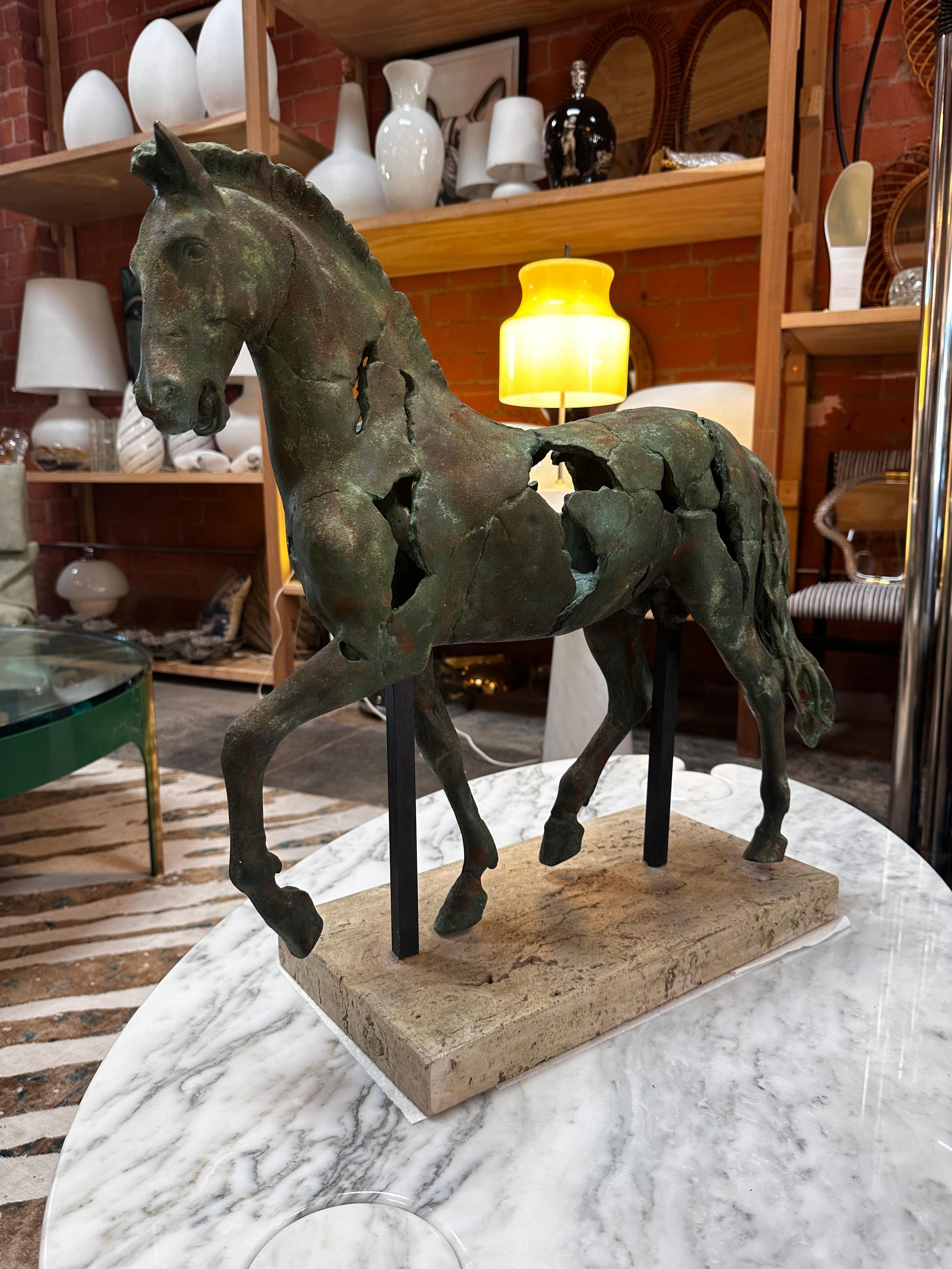 The Vintage Italian Bronze Horse Sculpture from the 1960s is a handmade masterpiece crafted in Italy. This exquisite sculpture features a horse made of bronze metal, elegantly positioned on a rectangular travertine base, showcasing both artistry and