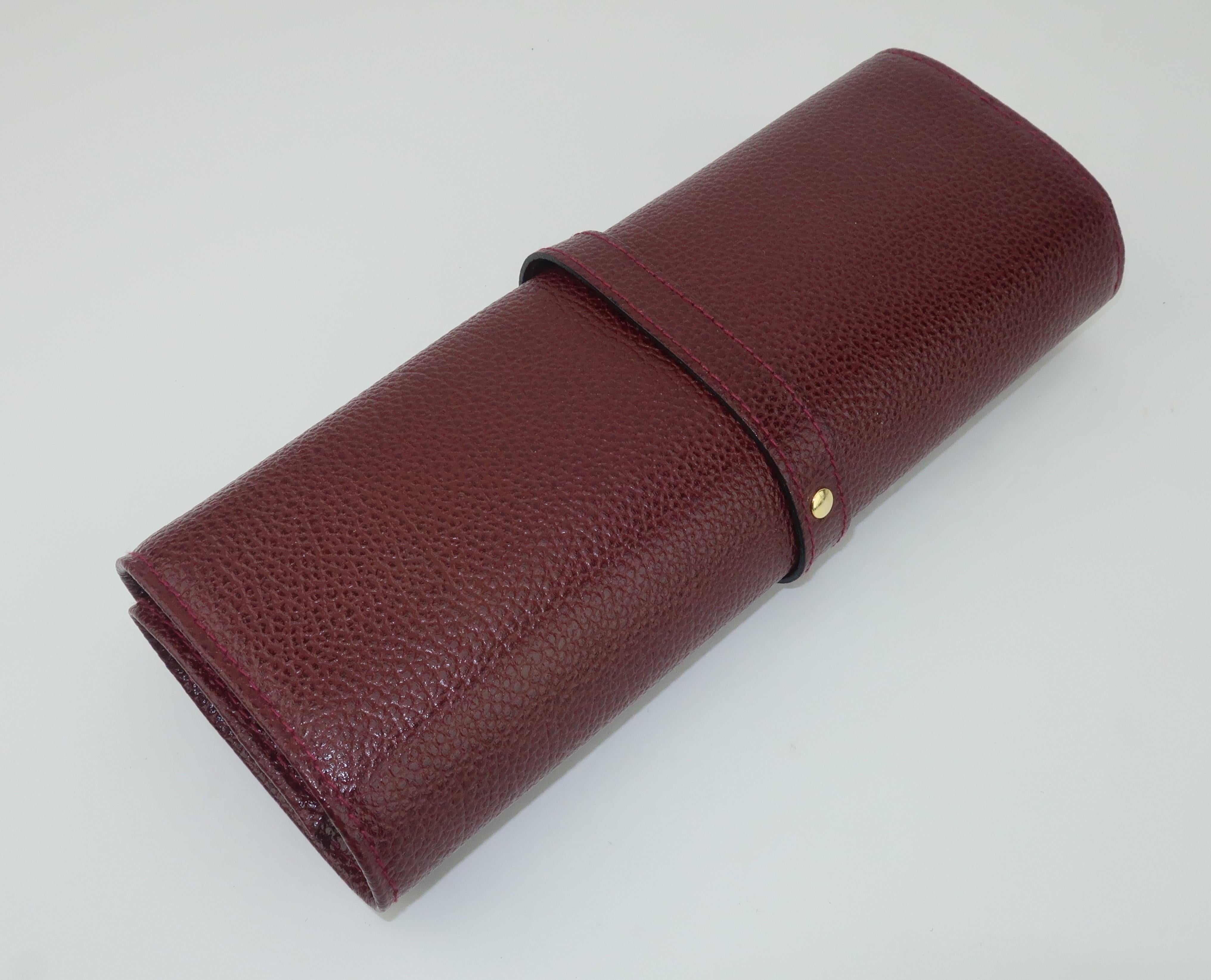 This vintage Italian burgundy pebbled leather case is a classically handsome method of keeping your jewelry safe while traveling or also useful as unobtrusive storage when at home.  The case offers four zippered compartments, a snap strap for rings