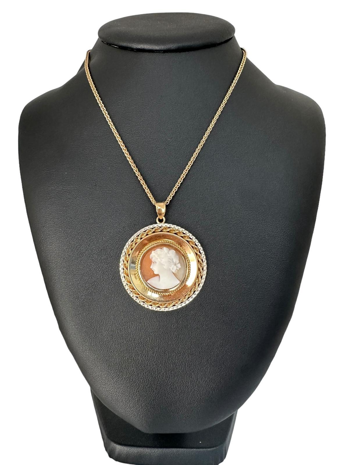 Este Colgante Camafeo Italiano Vintage es una pieza de joyería bellamente elaborada que combina la elegancia atemporal del arte del camafeo con una intrincada orfebrería. Fabricado en lujoso oro amarillo y blanco de 18 quilates, este colgante