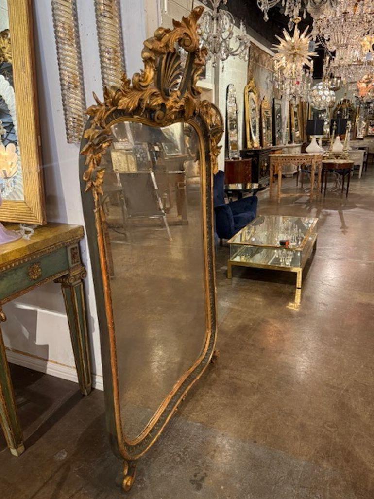Questo specchio d'epoca italiano intagliato e dorato vanta una splendida patina dorata con tocchi di nero e un'intricata cornice intagliata, che aggiunge un tocco di eleganza e raffinatezza a qualsiasi ambiente domestico. Anche lo specchio ha un