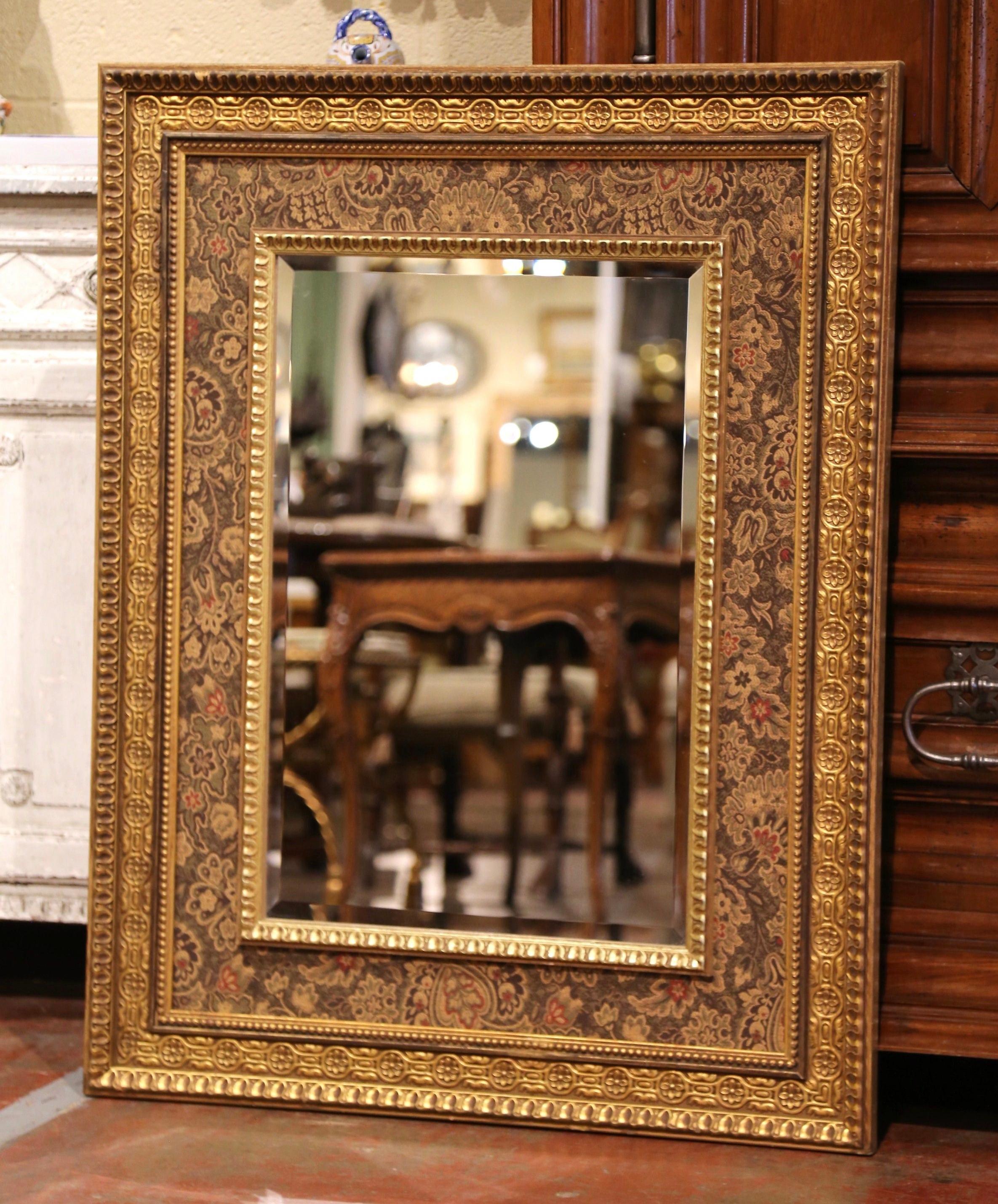 Decorate a powder room or bedroom with this elegant and colorful vintage mirror. Crafted in Italy circa 1980, the mirror features an ornate carved frame embellished with a Paisley fabric border. The frame is further dressed with a beveled mirror.