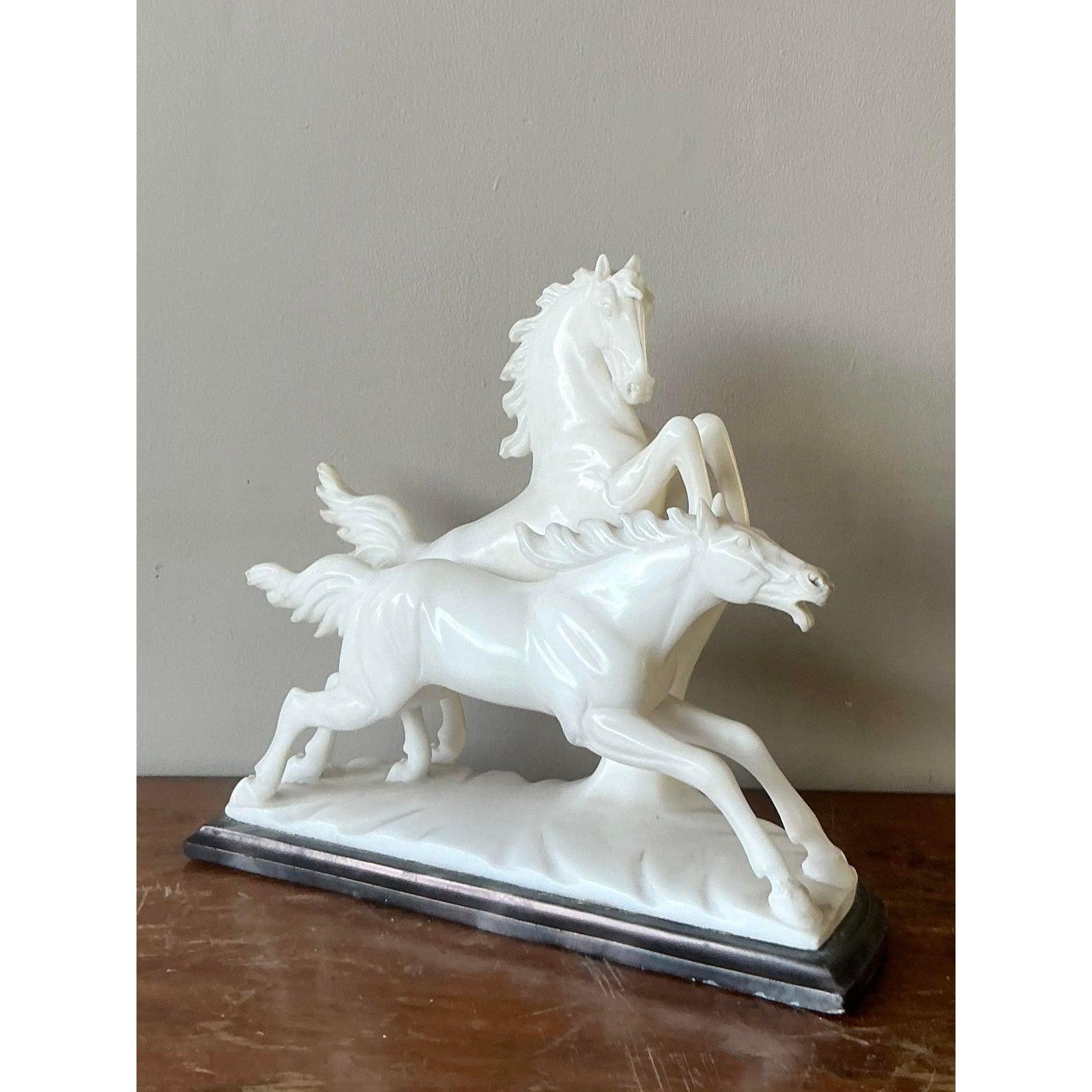 Infunde a tu decoración la energía dramática de esta exquisita escultura italiana vintage de caballo. Impresionante ejemplo de talla magistral, esta pieza representa a dos poderosos sementales en pleno movimiento: uno se encabrita majestuosamente