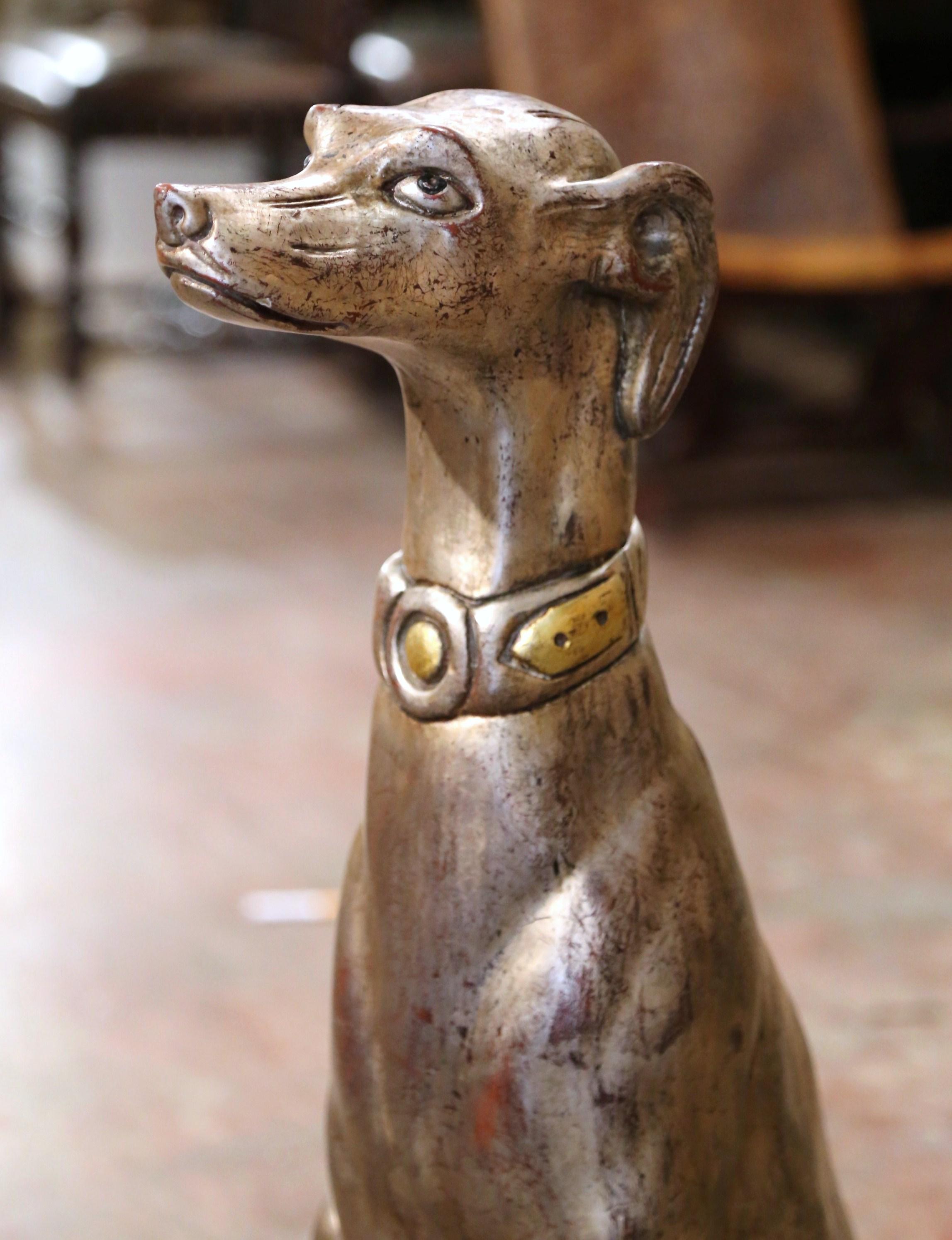 Hand carved near Venice, Italy, circa 1960, this large antique sculpture sits on an integral square red and gilt wooden pillow base; it features a greyhound figure sitting on back legs, its head up at attention as if ready to follow any command