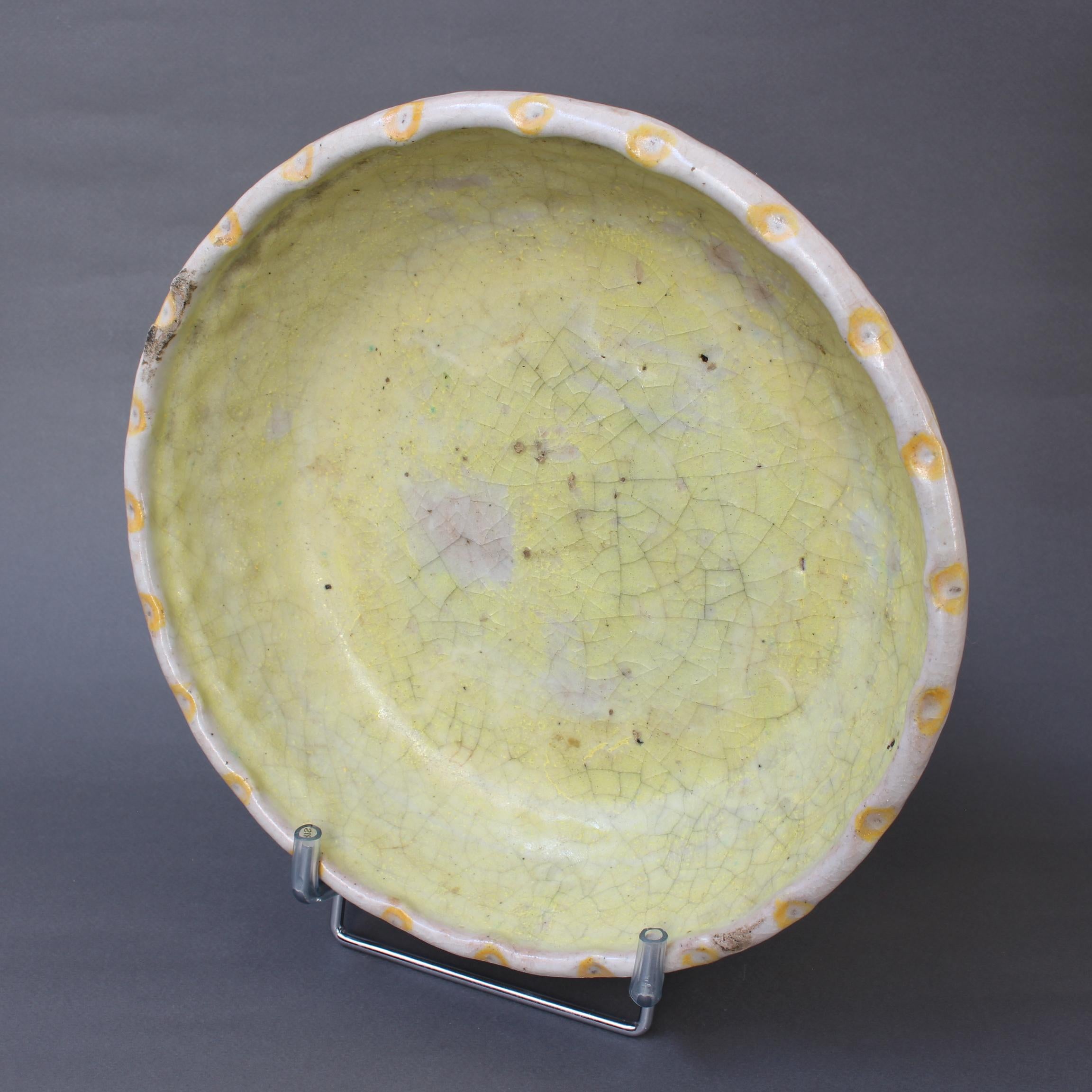 Decorative Italian ceramic fruit bowl by Guido Gambone (circa 1930s). Handmade and painted in a dreamy yellow glaze with crackle effect. The exterior is adorned with dimples below the lighter coloured lip. In fair overall condition commensurate with