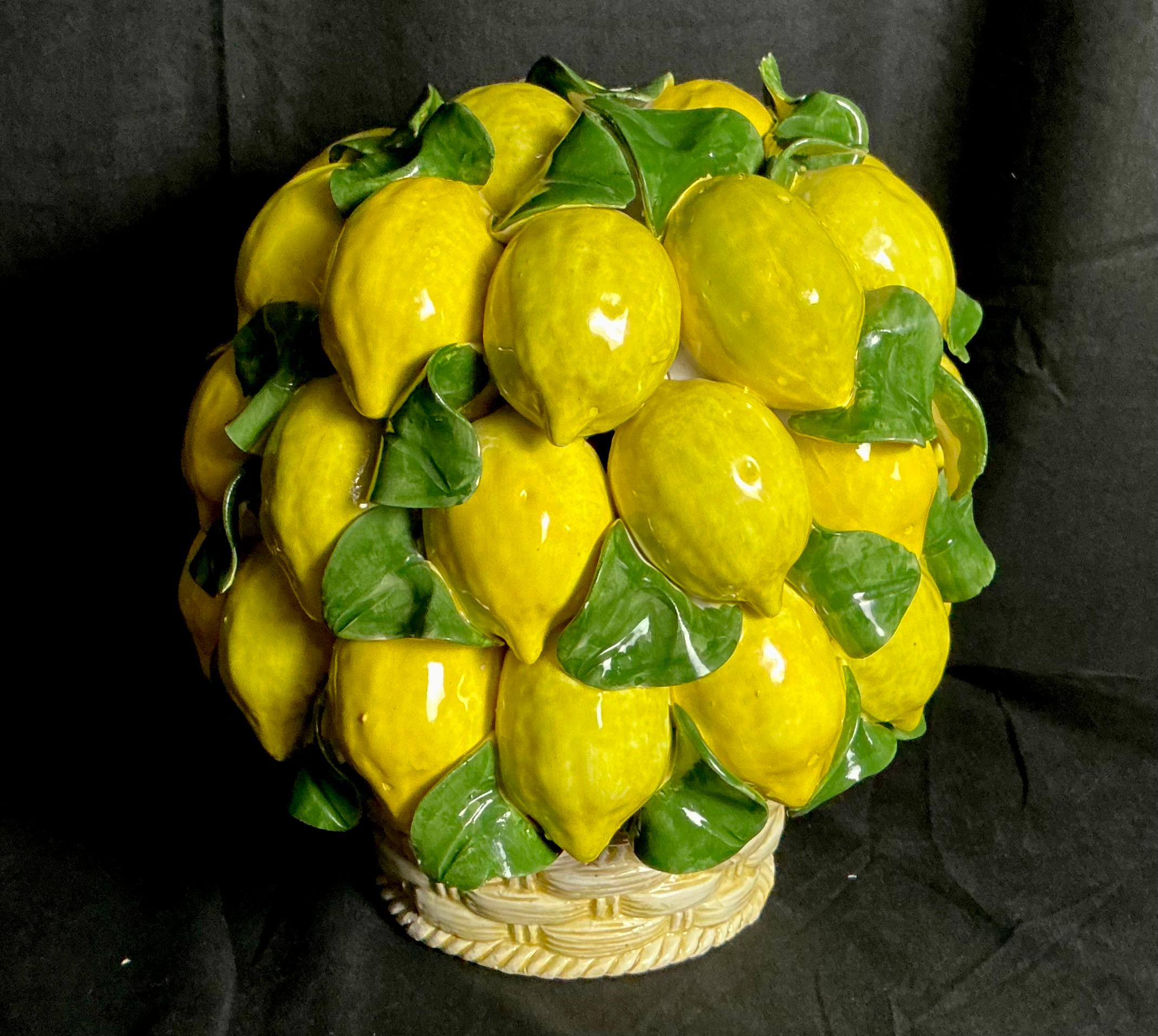 Albero di limoni in ceramica della metà del XX secolo. Il pezzo presenta una lussureggiante composizione di limoni gialli dipinti a mano con foglie verdi lucide, il tutto inserito in una base di cesto intrecciato finemente modellata. Lo smalto