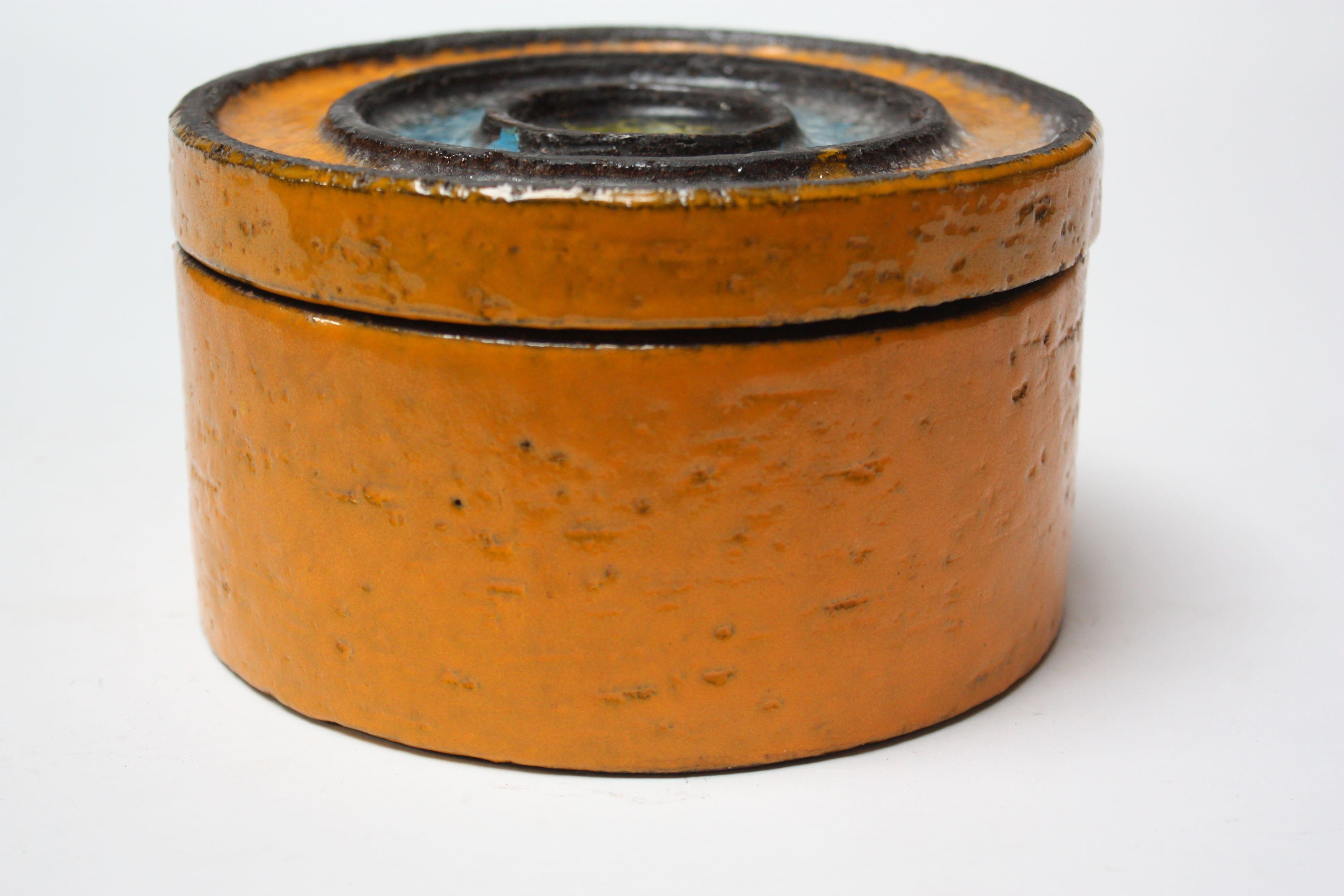 This 1960s Italian ceramic lidded jar is a gorgeous combination of chartreuse, sky blue, charcoal, and burnt orange. The glaze used on the top of the lid creates a 'glass' or 'crystal-like' appearance and makes for a nice contrast to the matte glaze