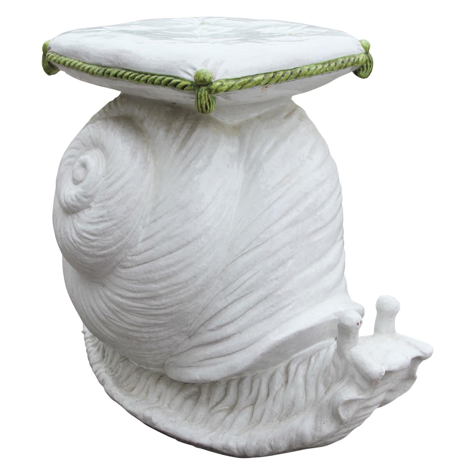 Super chic garden seat accent stool in the shape of a stylized snail made of white glazed terracotta and a top that resembles a tufted cushion with matching green buttons and tassels. The garden seat is in great condition.