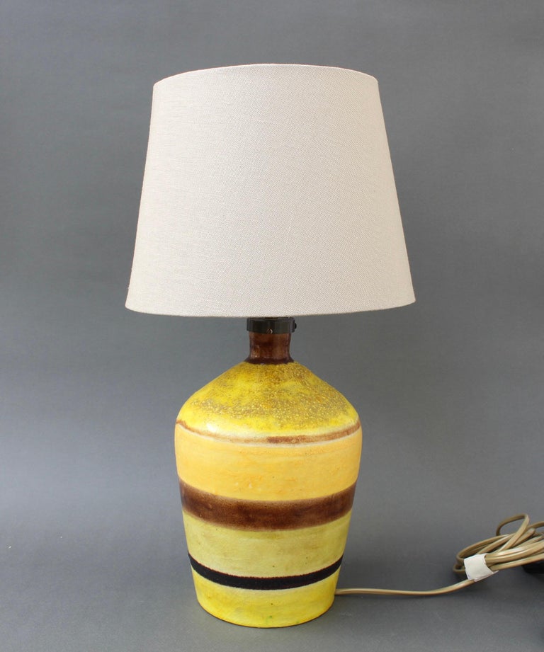 Mid-century Italian ceramic table lamp base by Guido Gambone (circa 1950s). The piece is hand painted in vibrant yellow with craquelure in some of the horizontal layers. The other horizontal layers are painted in a soft caramel brown and another,