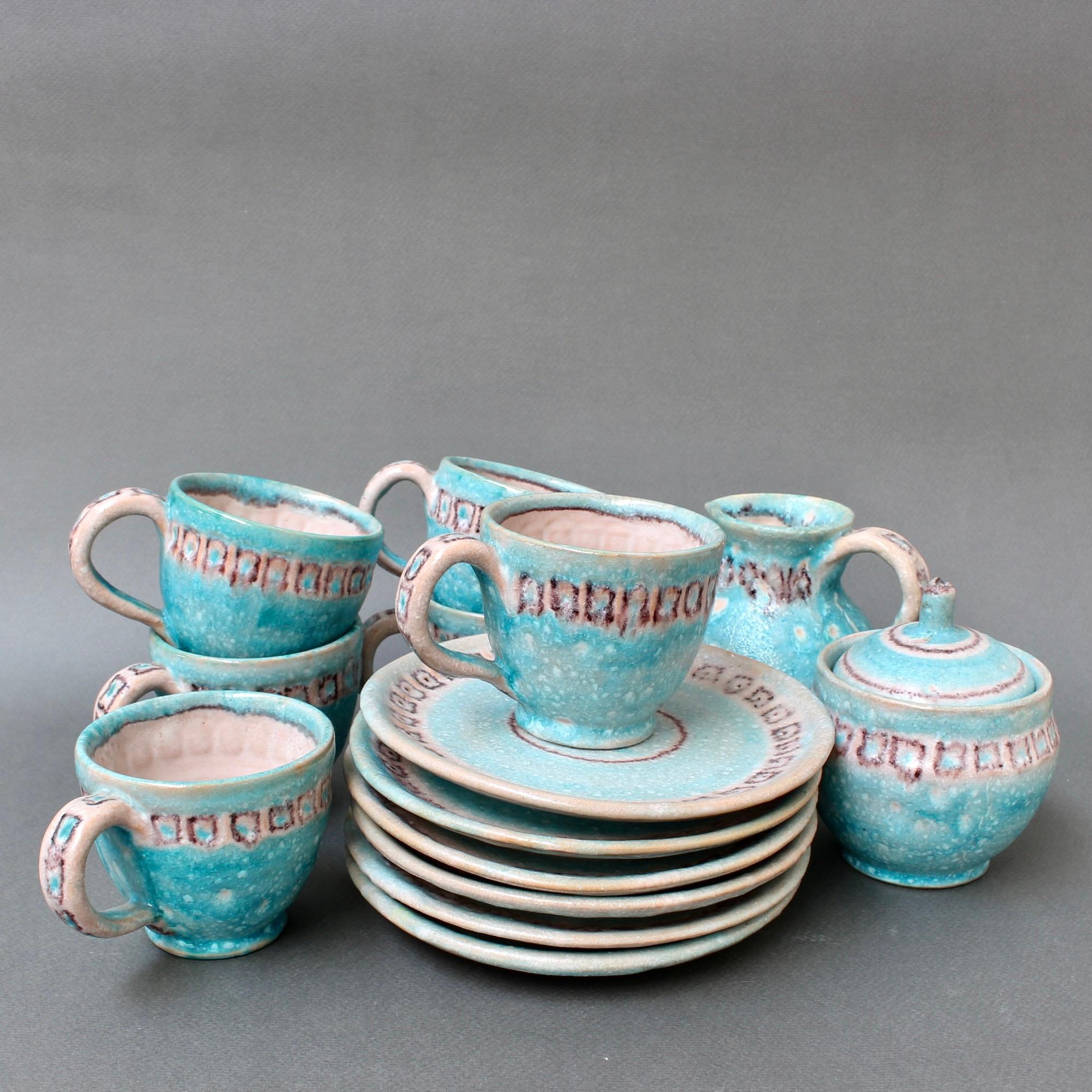 mid-century Italian ceramic tea / coffee set by Guido Gambone (circa 1950s). A full set of six cups and saucers, a creamer and sugar bowl all in Gambone's inimitable style. The set is hand-painted with geometric shapes in brown over a lively powder