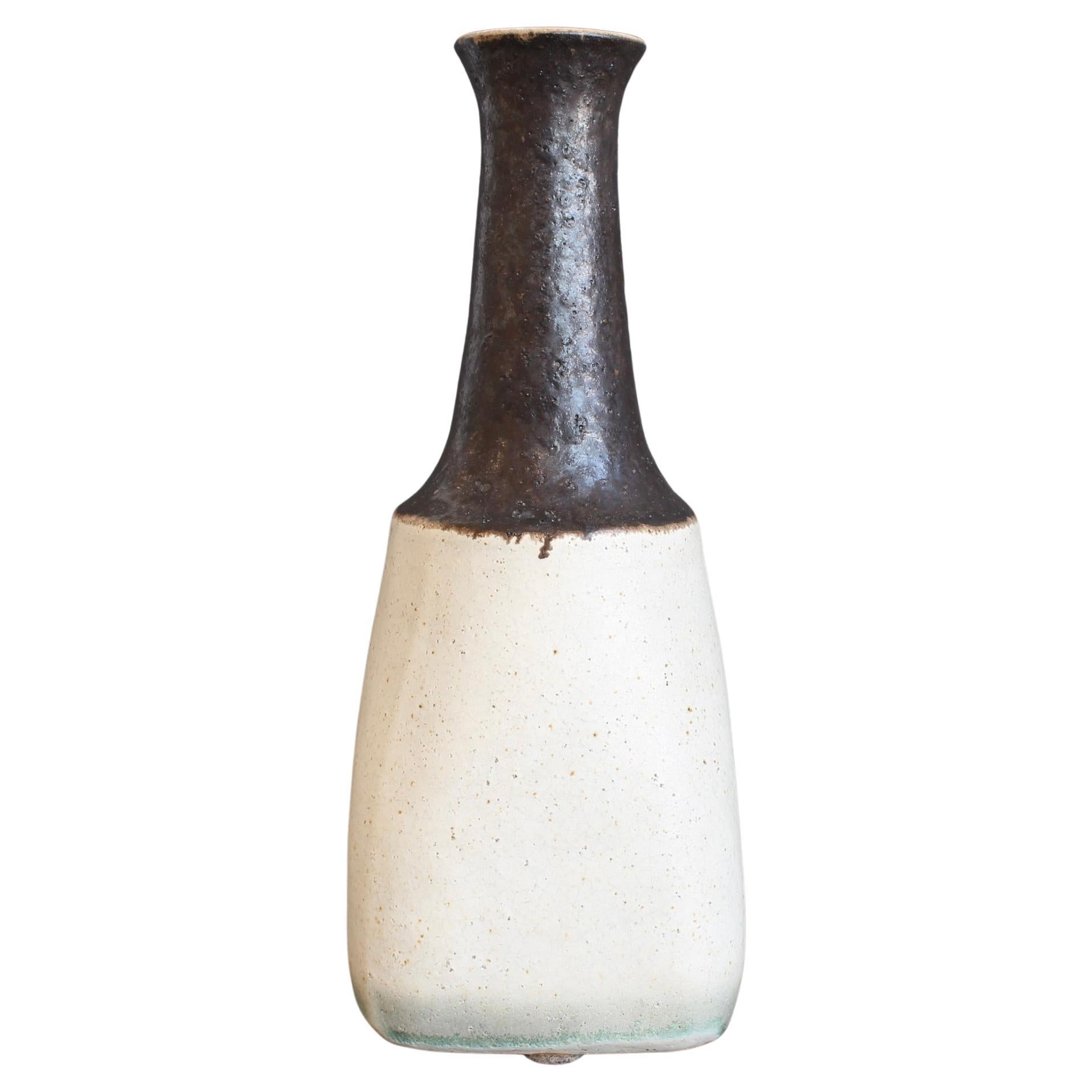 Dekorative italienische Keramikvase von Bruno Gambone (ca. 1980er Jahre). Ein sinnliches flaschenförmiges Stück mit einem hafermehlfarbenen, breiten Boden, der sich nach oben hin zu einem schokoladenbraunen, länglichen Hals mit einer elegant