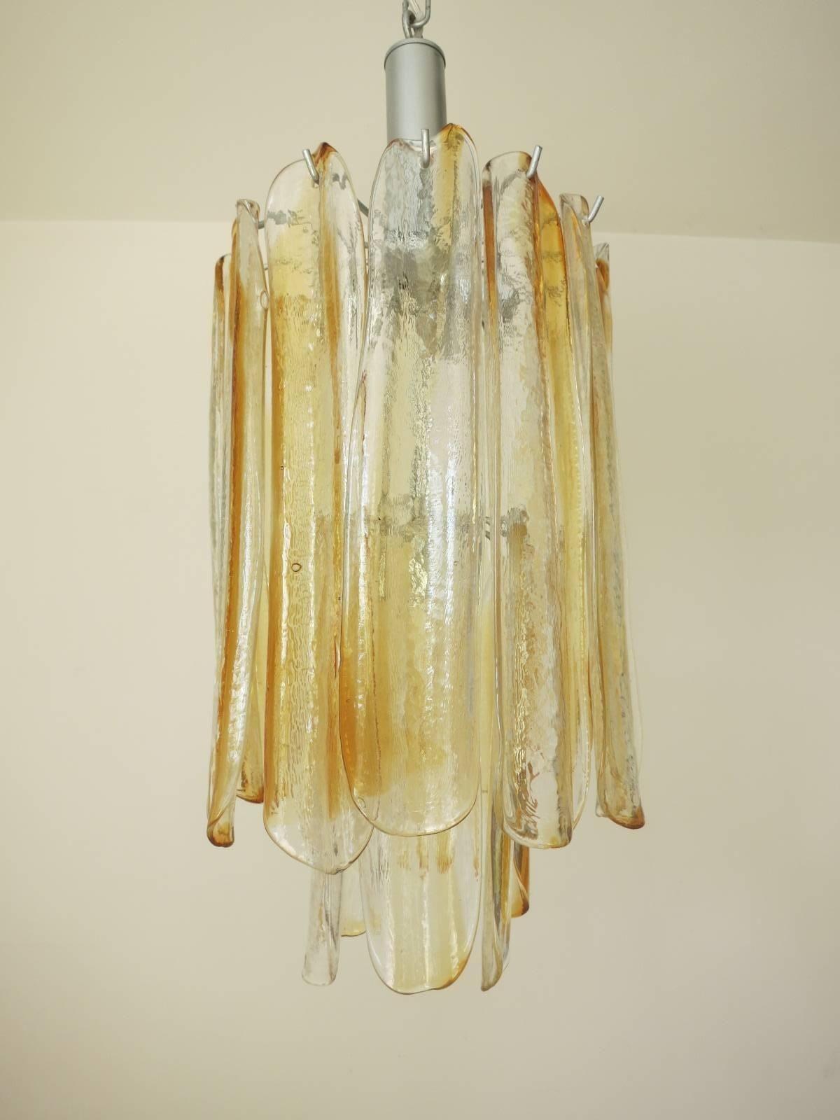 This stunning vintage chandelier consists of 18 infused amber and clear Murano glass petals stacked in two tiers, mounted on a nickel painted metal frame. Designed by Mazzega, Italy, c. 1960's.
Dimensions:
26.5