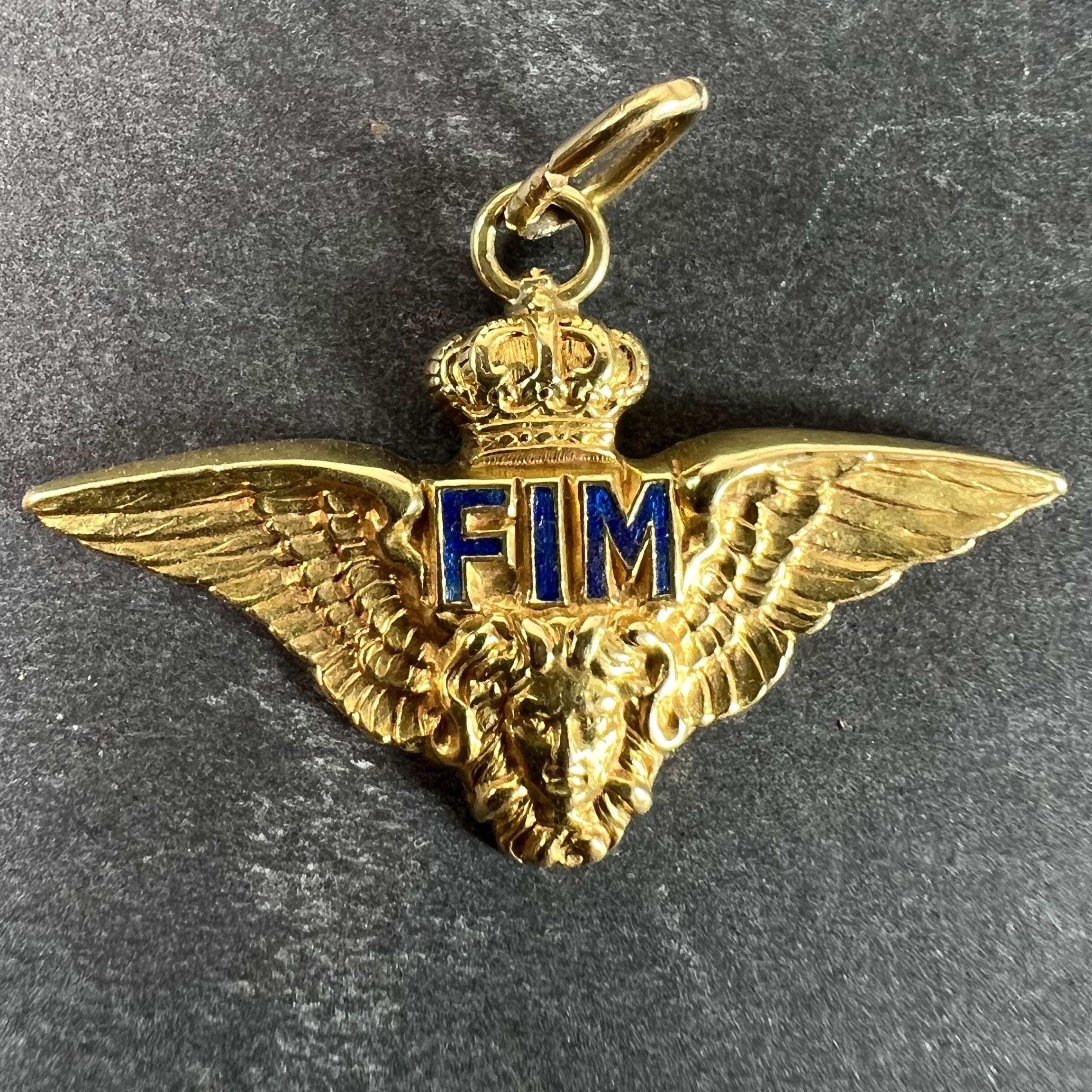 Un ciondolo charme in oro giallo Art Deco (18 carati) disegnato come simbolo dell'Aeronautica Militare, con un paio di ali con una corona sopra e un volto sotto (forse di Medusa - due ciocche assomigliano a serpenti). Le lettere FIM sotto la corona