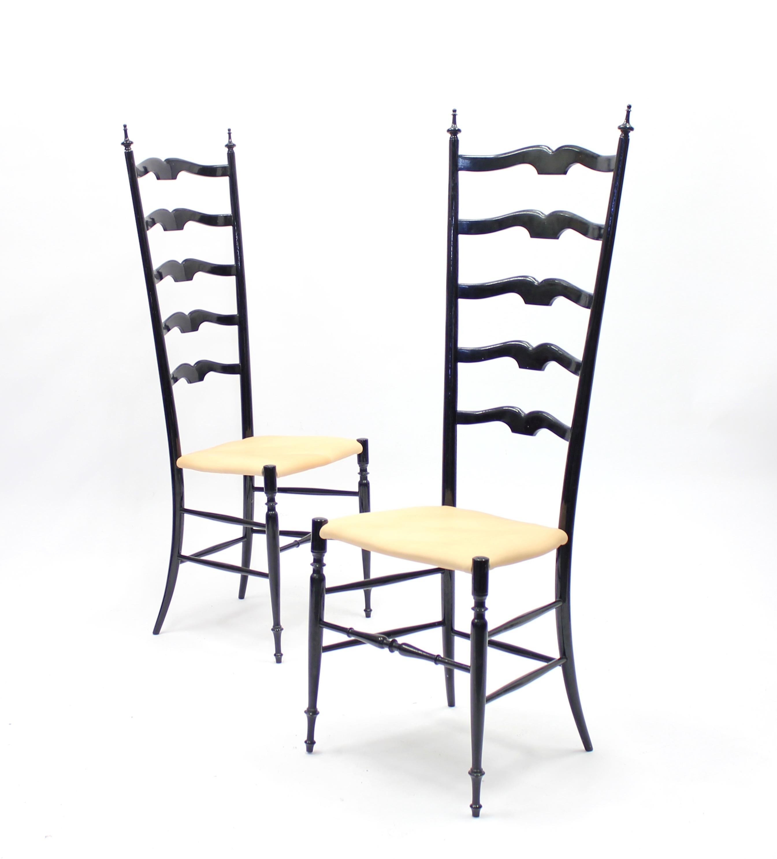 Pair of vintage midcentury Chiavari chairs, reupholstered in a vintage natural colored leather. Frame of lathed original black lacquered wood. Very good vintage condition, the vintage leather has some nuance differences. The first Chiavari chair was