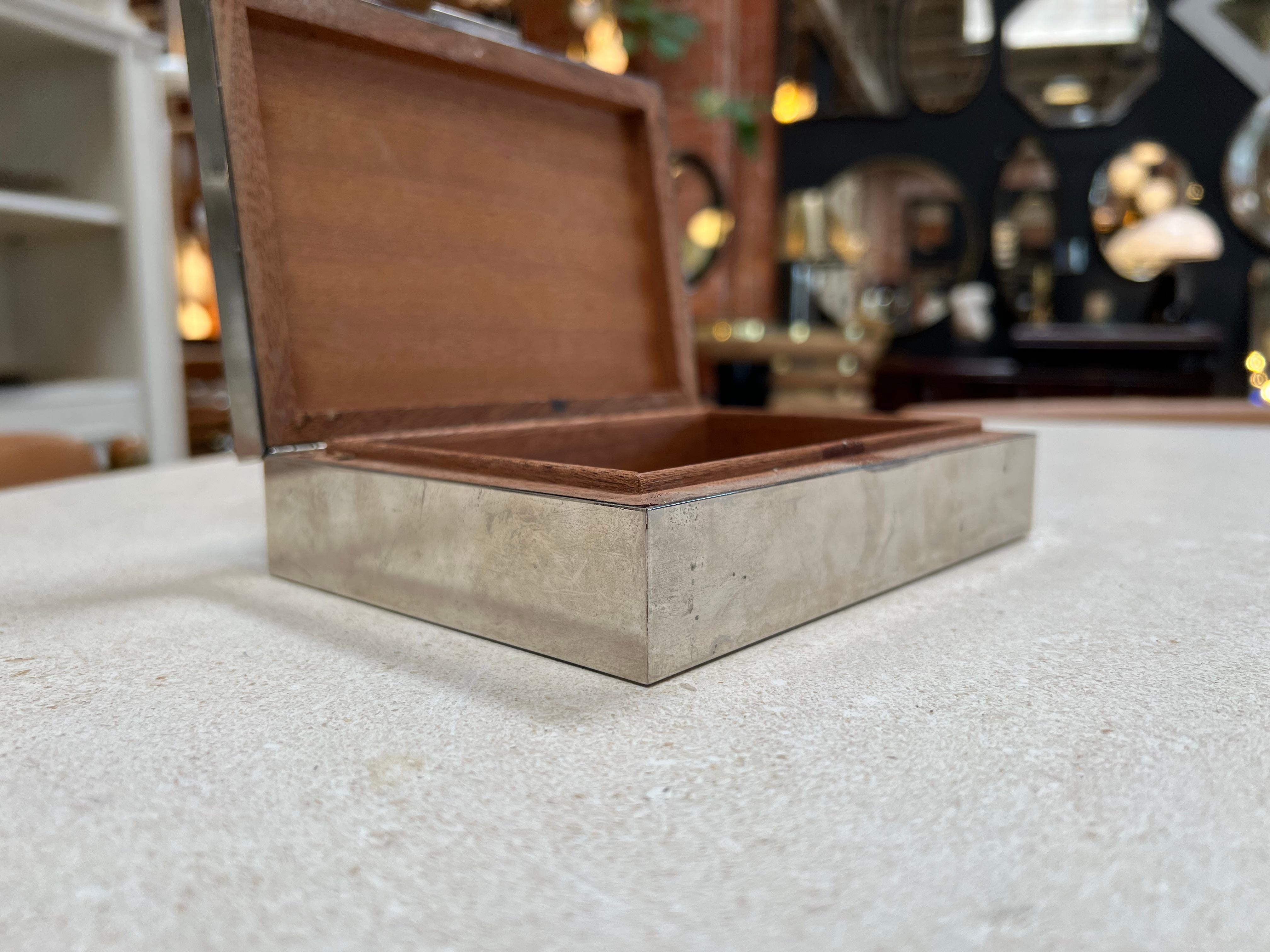 Cette boîte décorative italienne vintage en chrome avec un plateau en pierre, fabriquée dans les années 1960, incarne l'élégance du design italien du milieu du siècle. Elle présente un mélange harmonieux de chrome poli et d'une surface en pierre